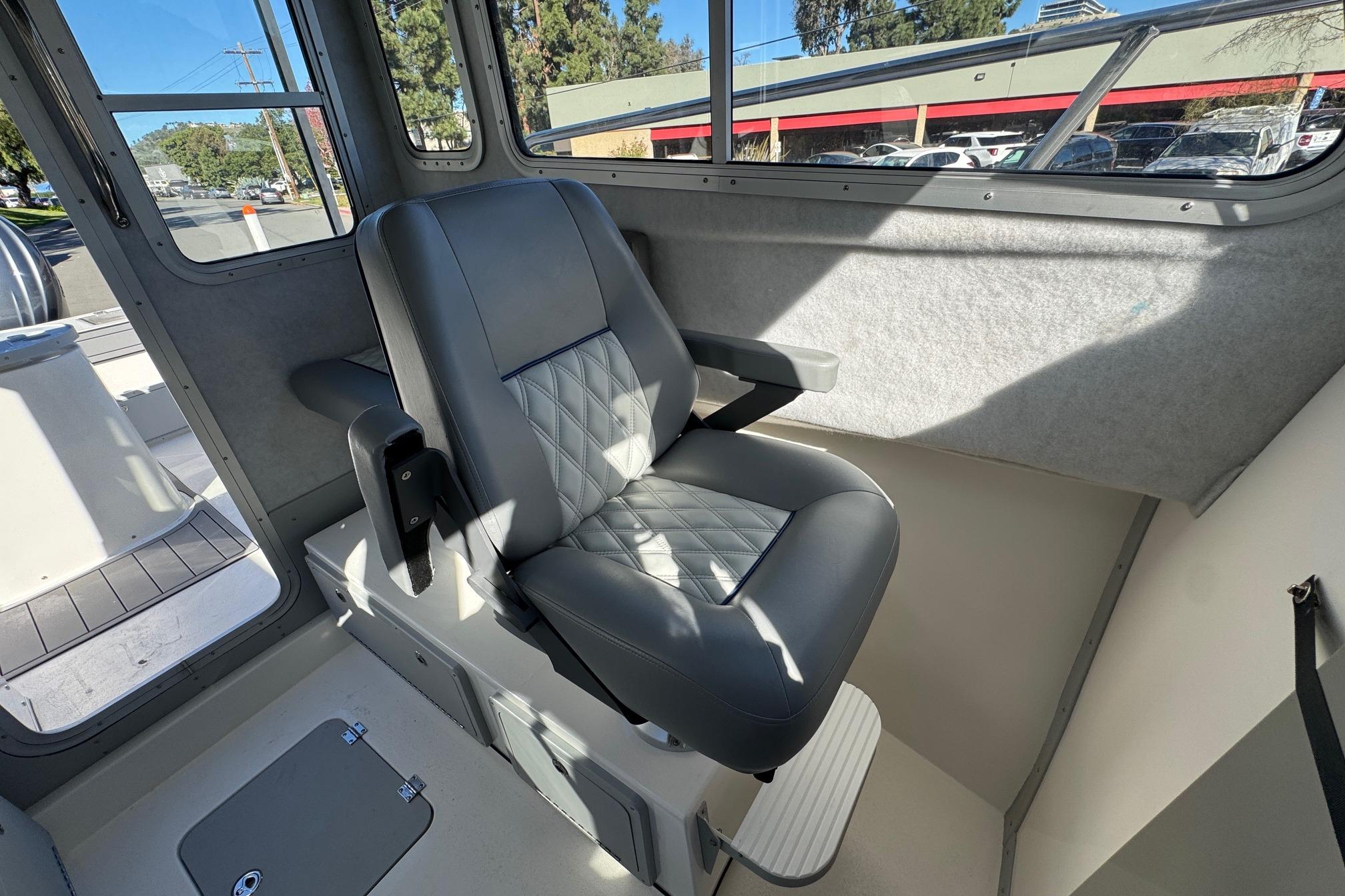 Interior of 2026 Defiance Admiral 250 EX boat with a cushioned captain's chair.
