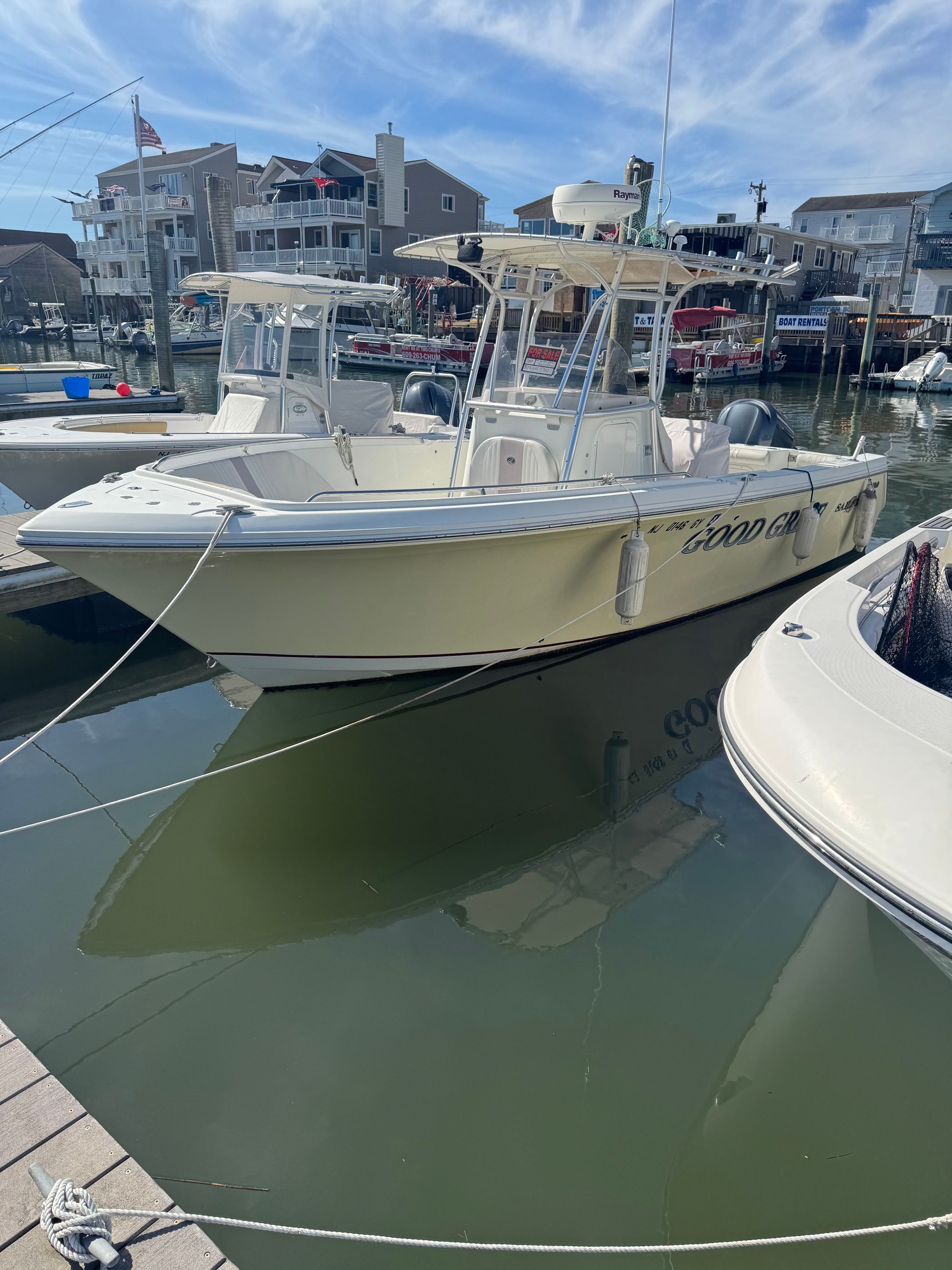 2006 Sailfish 2360 CC boat docked in harbor.