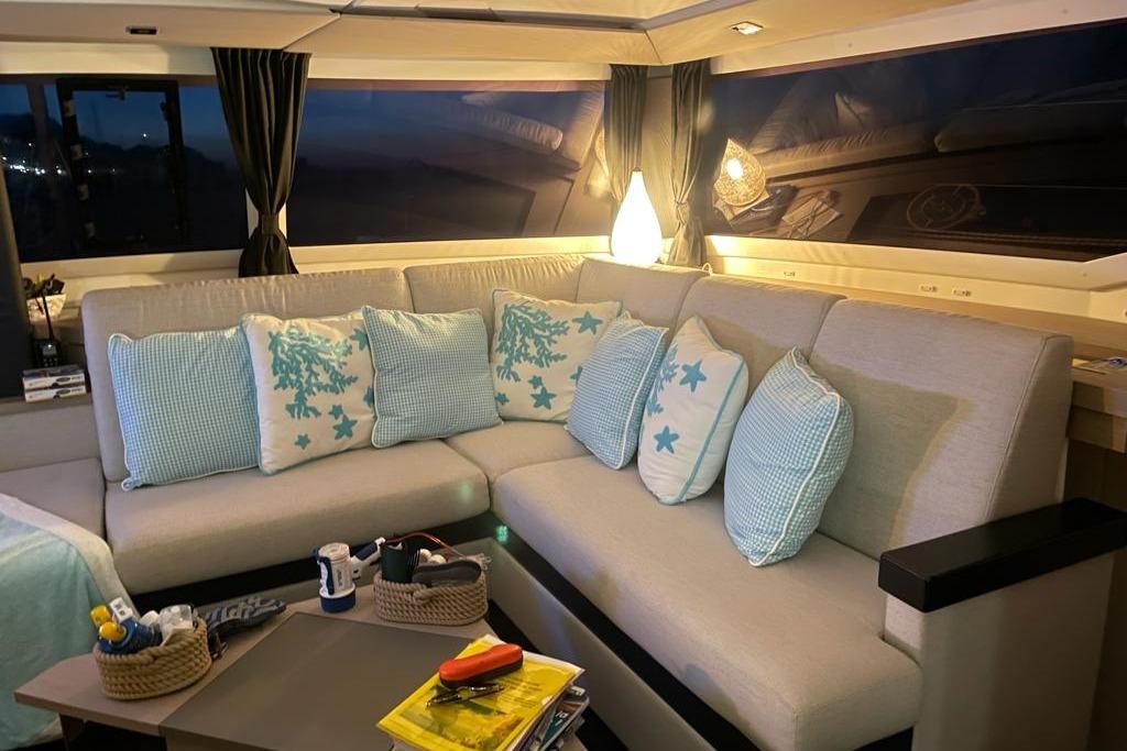 Luxurious interior of 2020 Fountaine Pajot Saona 47 yacht with cozy seating and decorative pillows.