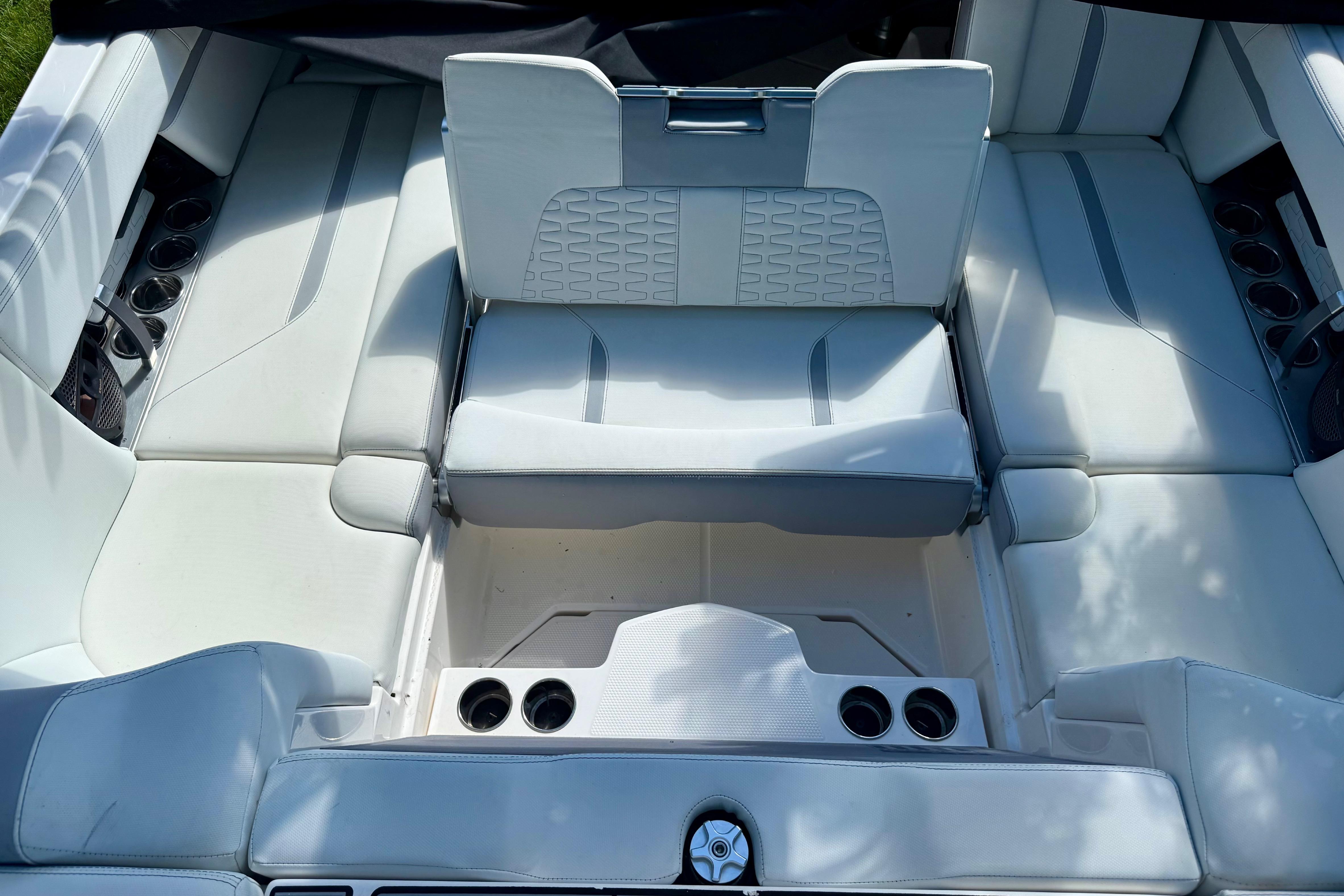 2023 MasterCraft X24 boat interior with white seating and cup holders.