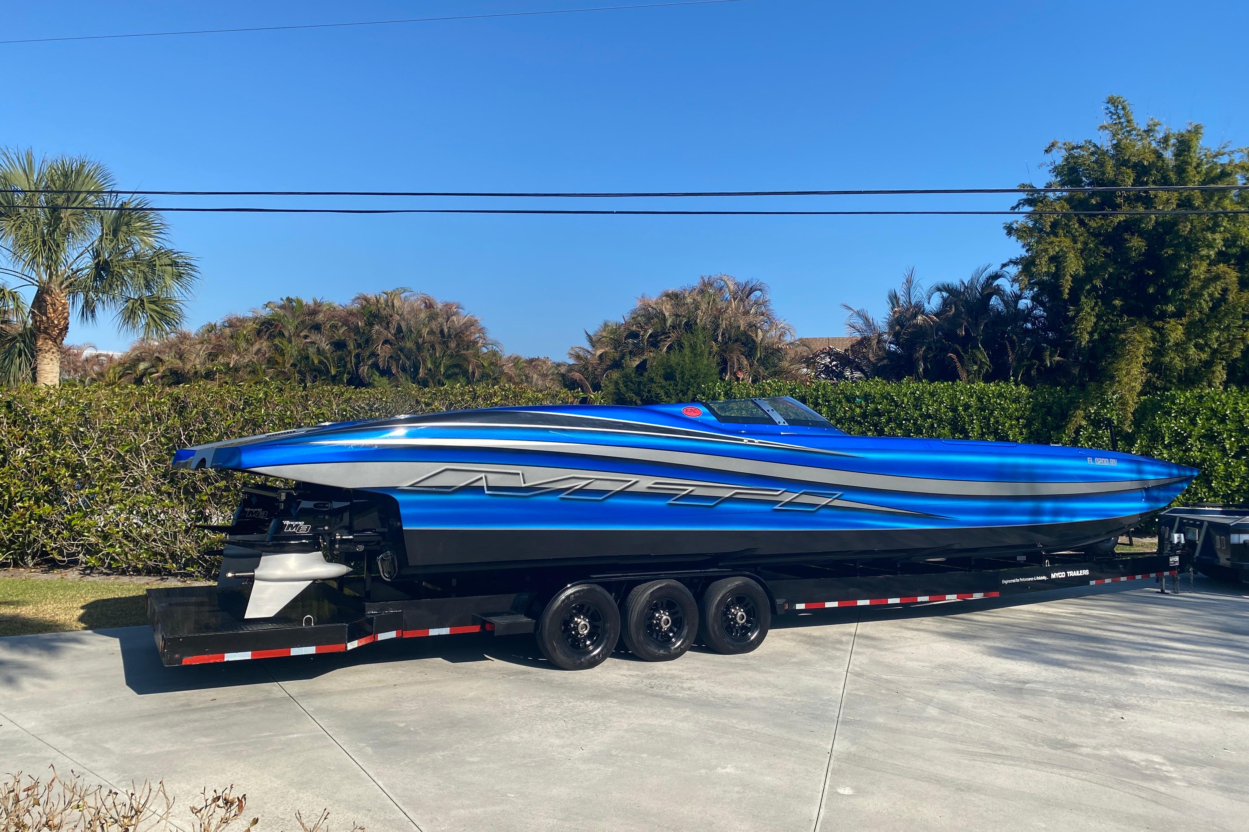 2016 MTI 44 RP speedboat on trailer, vibrant blue design, parked outdoors.