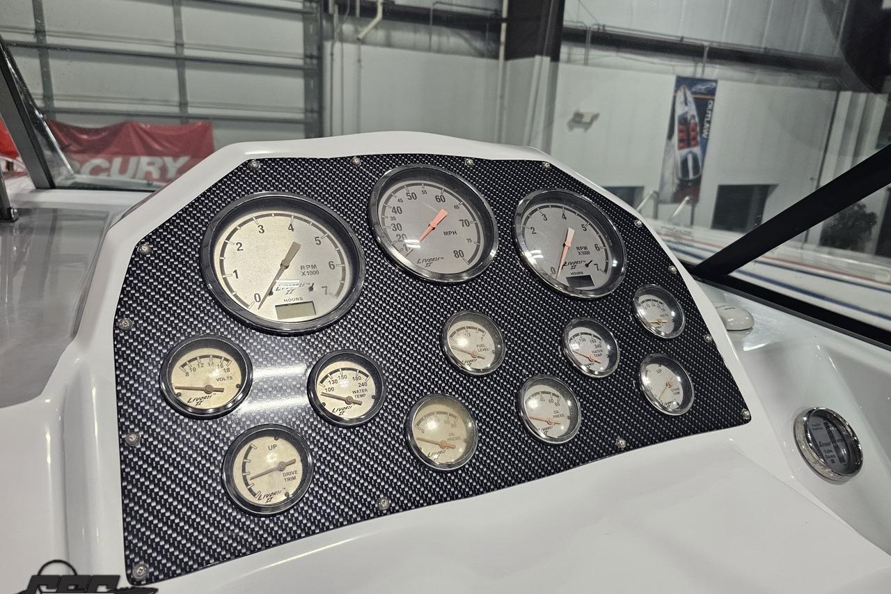 Dashboard of a 2008 Baja 335 Performance boat with multiple gauges and carbon fiber panel.