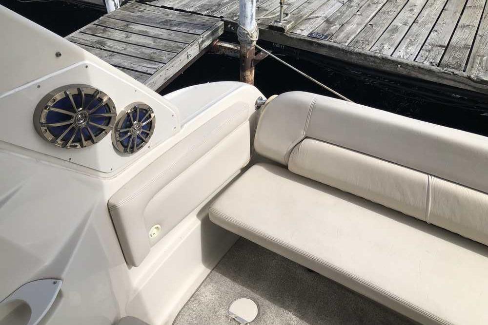 Interior of 1999 Regal Commodore 2760 boat with beige seating and speakers.