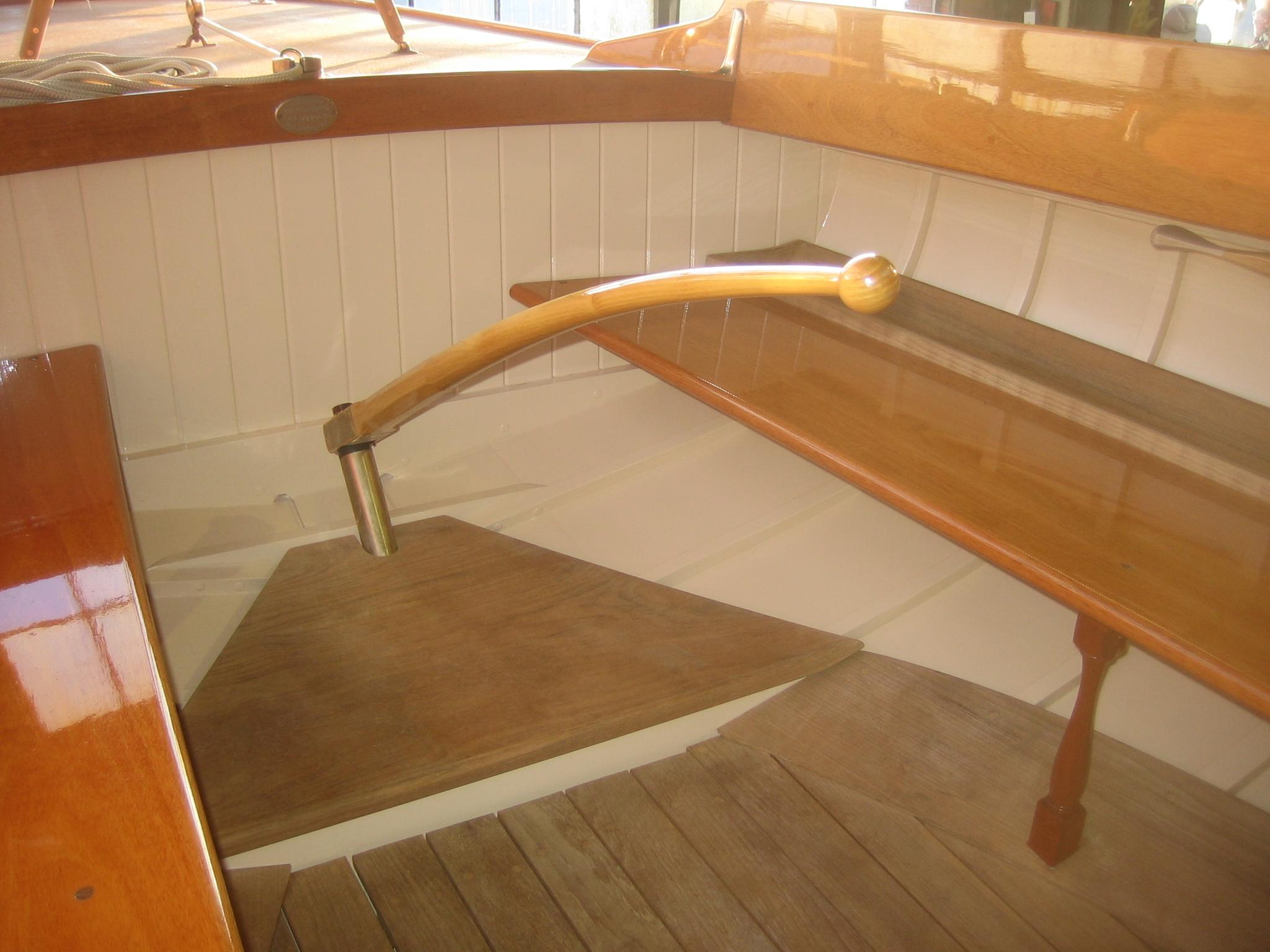 Interior of 2008 Herreshoff Full-Keel Buzzards Bay 15 sailboat, featuring wooden tiller and deck.