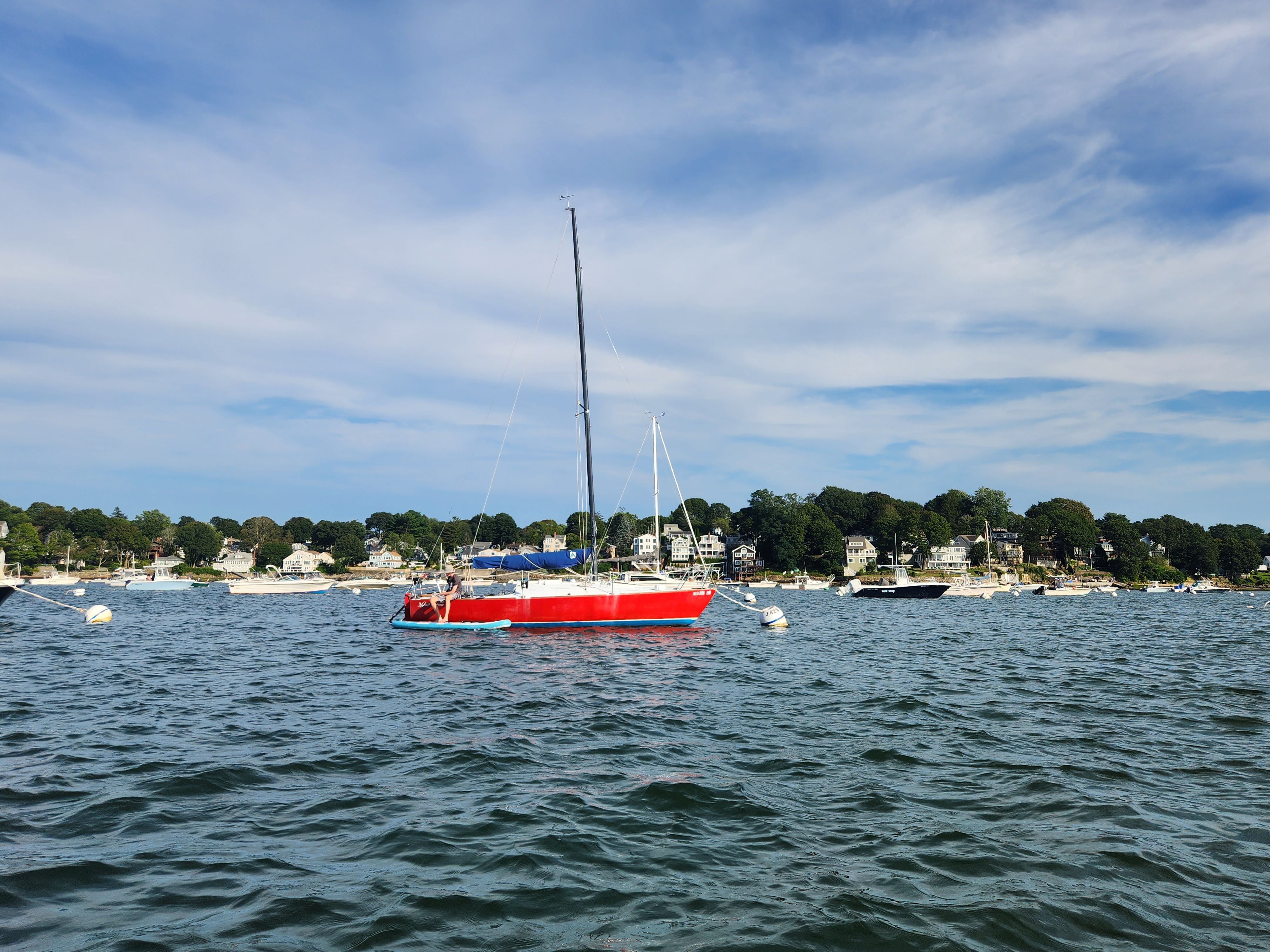 Red 1978 J/24 sailboat on calm waters.