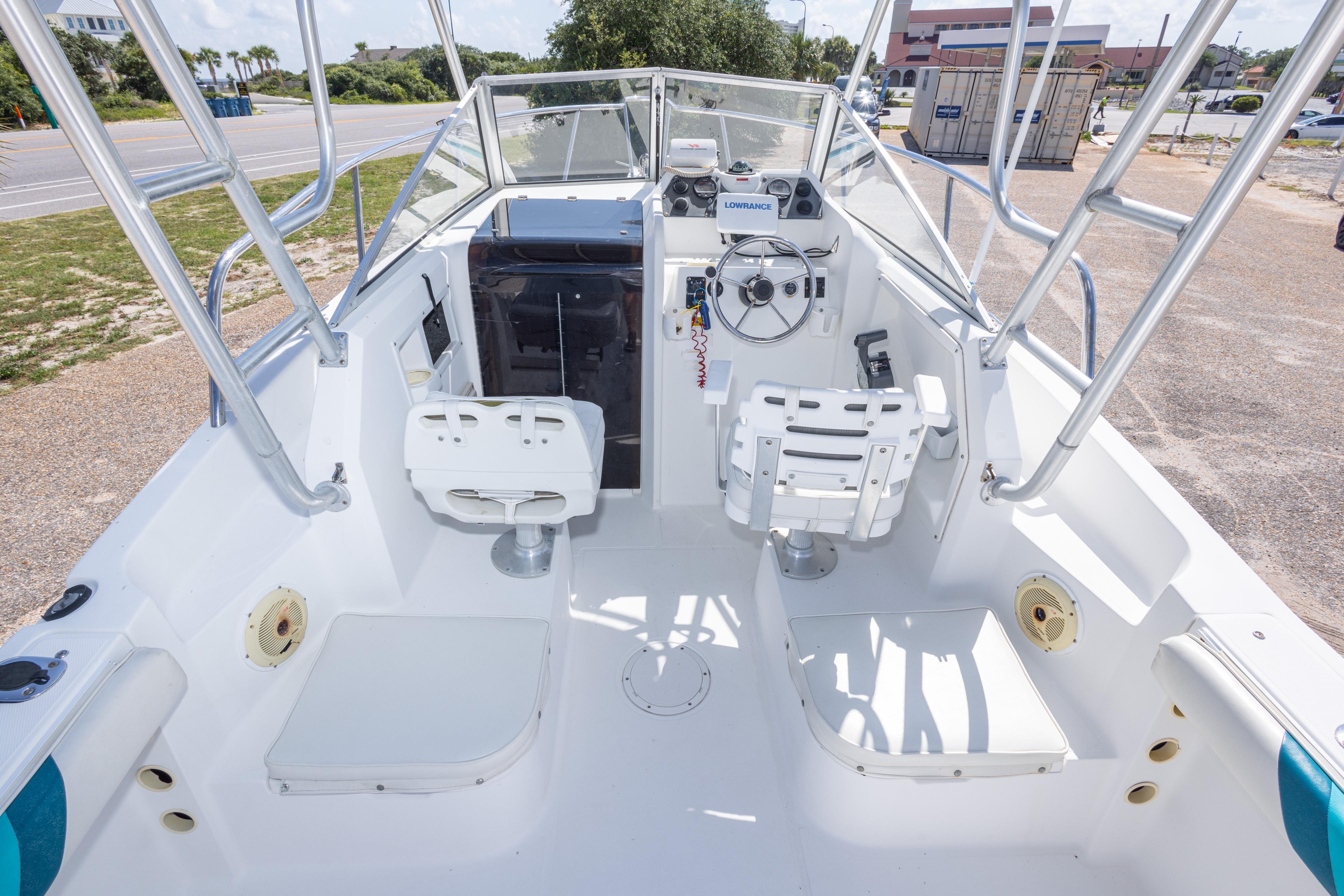1999 Aquasport 225 Explorer boat interior with steering wheel and seating.