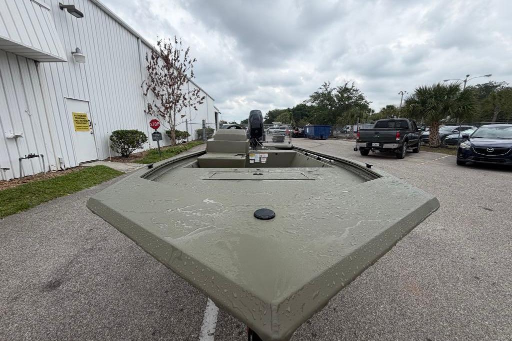 2026 Tracker Grizzly 1648 SC boat parked outdoors on a cloudy day.