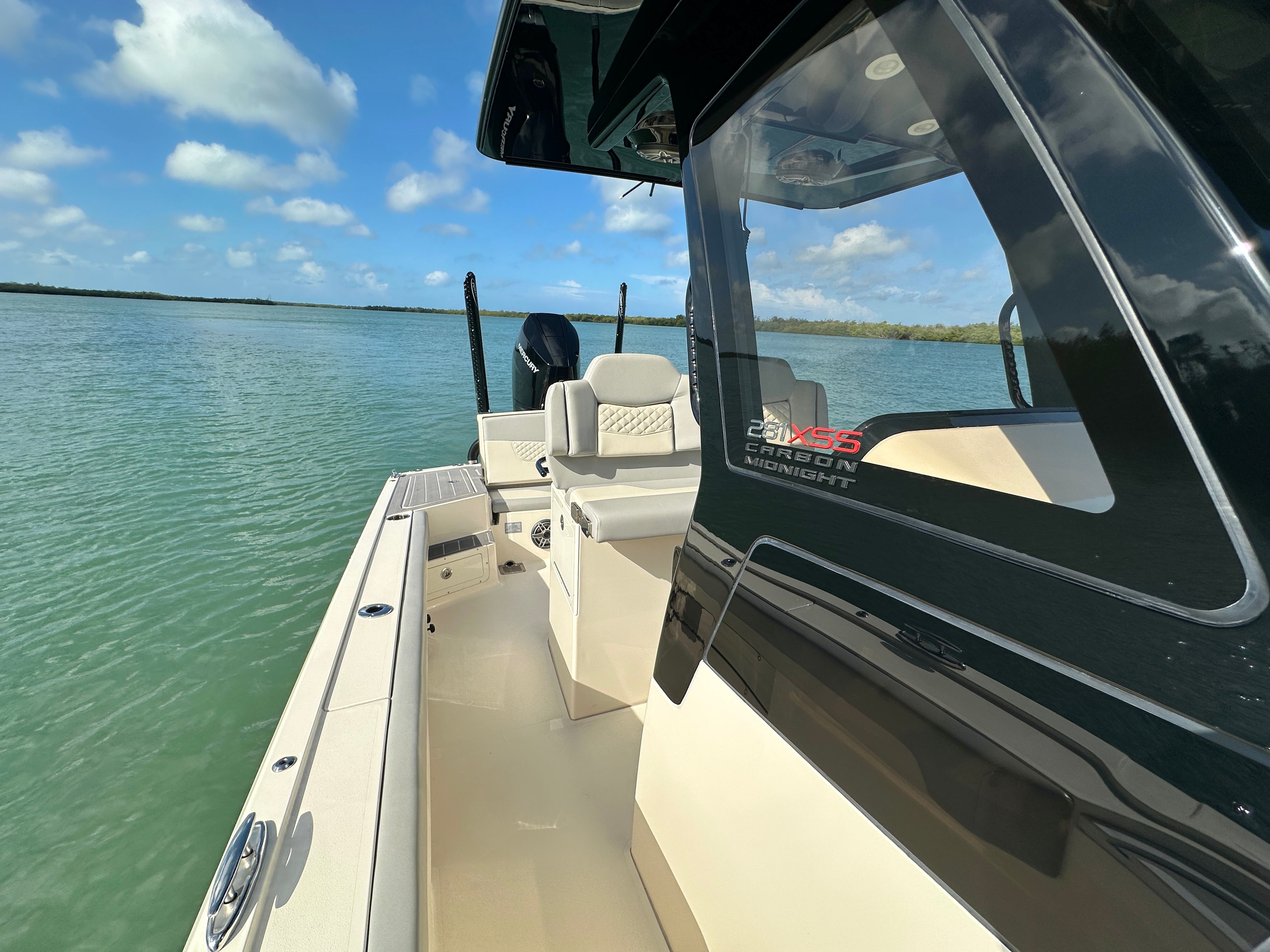 A 2024 Scout 281 XSS boat on calm water with a clear view of the cockpit.