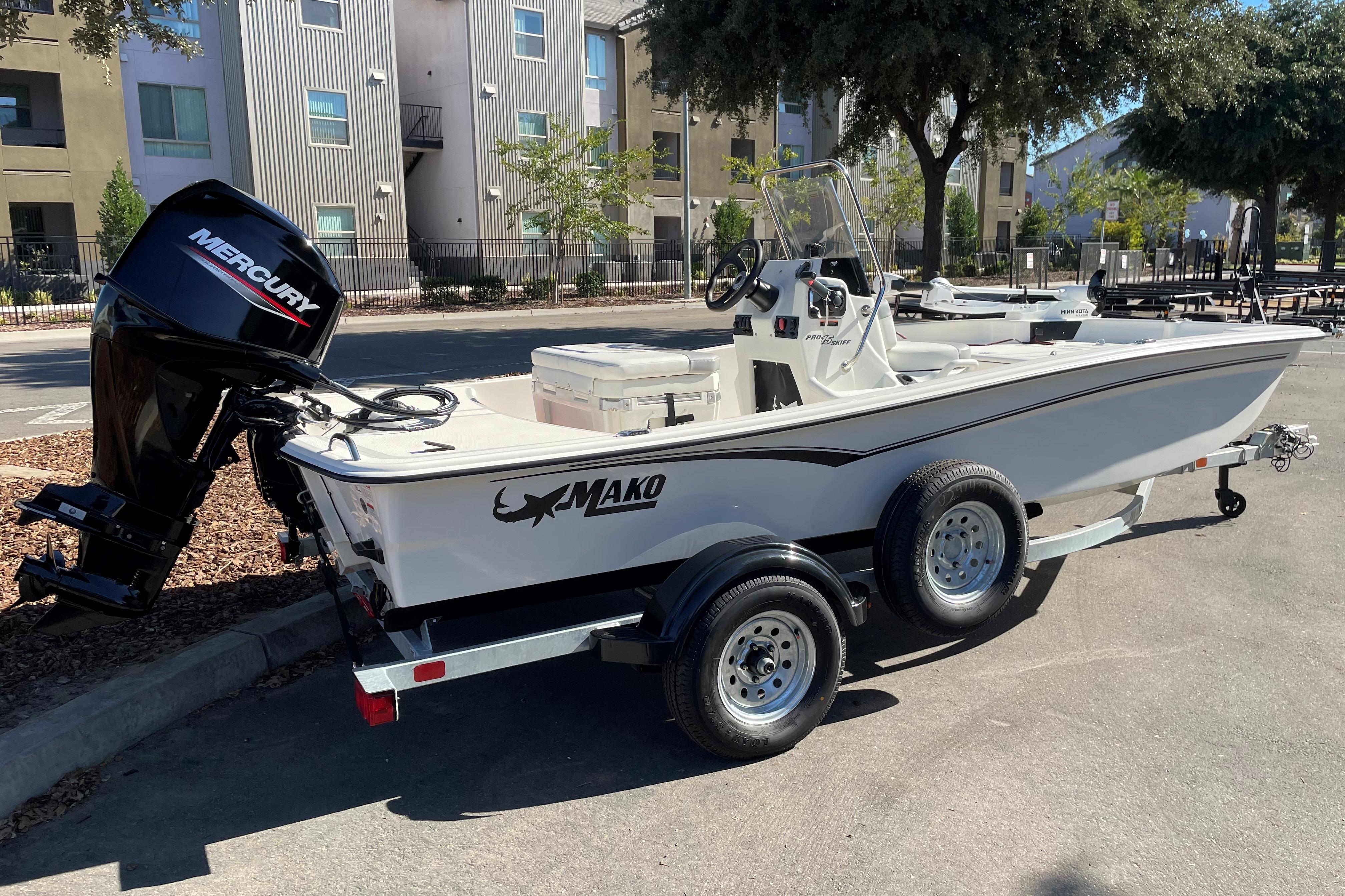 2025 Mako Pro Skiff 15 CC boat on trailer, parked outdoors with Mercury engine.