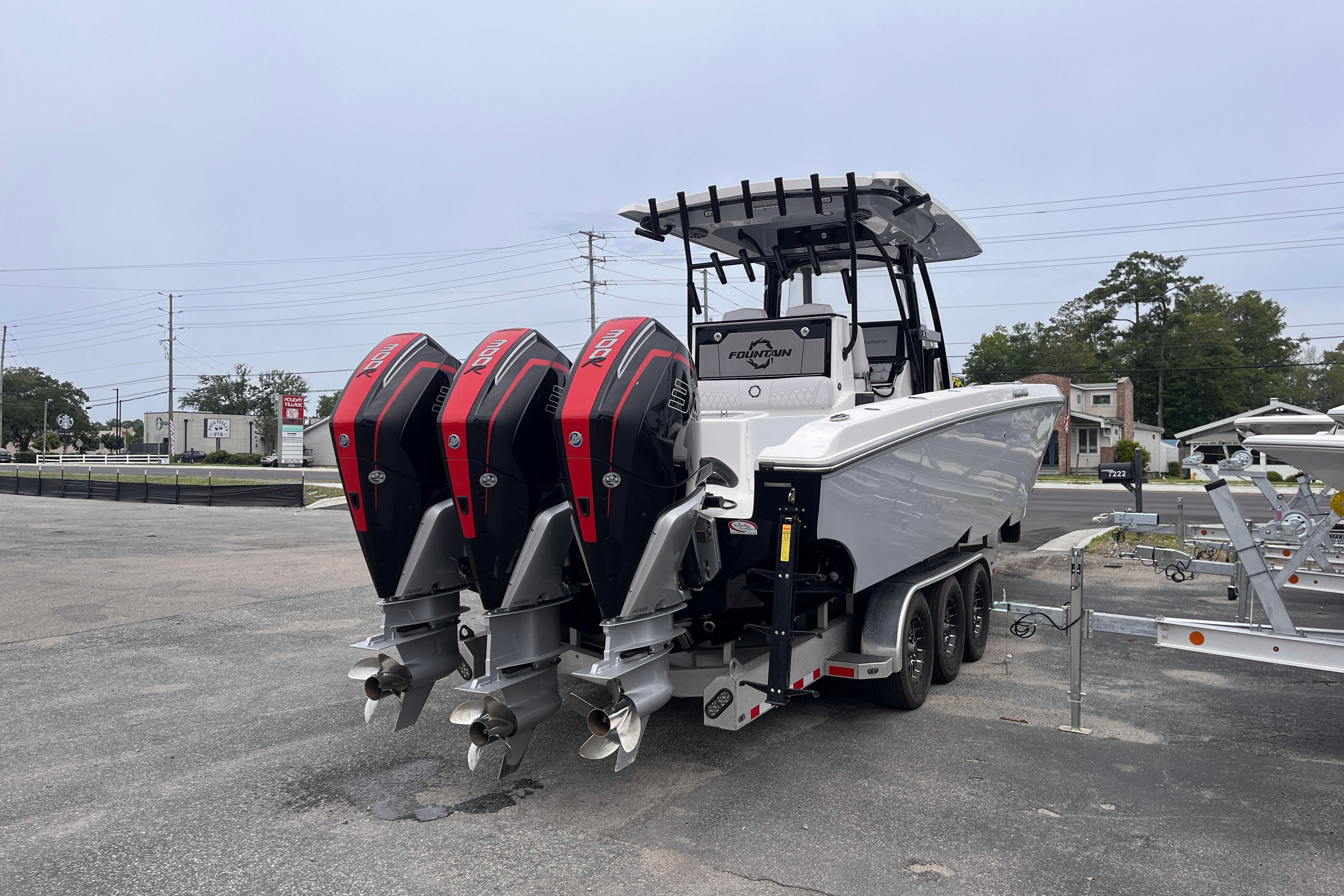 2024 Fountain 34 Tournament Edition boat with triple outboard engines in a parking lot.