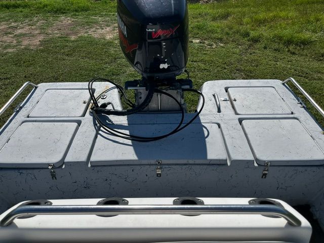 A boat with an outboard motor on a grassy area.