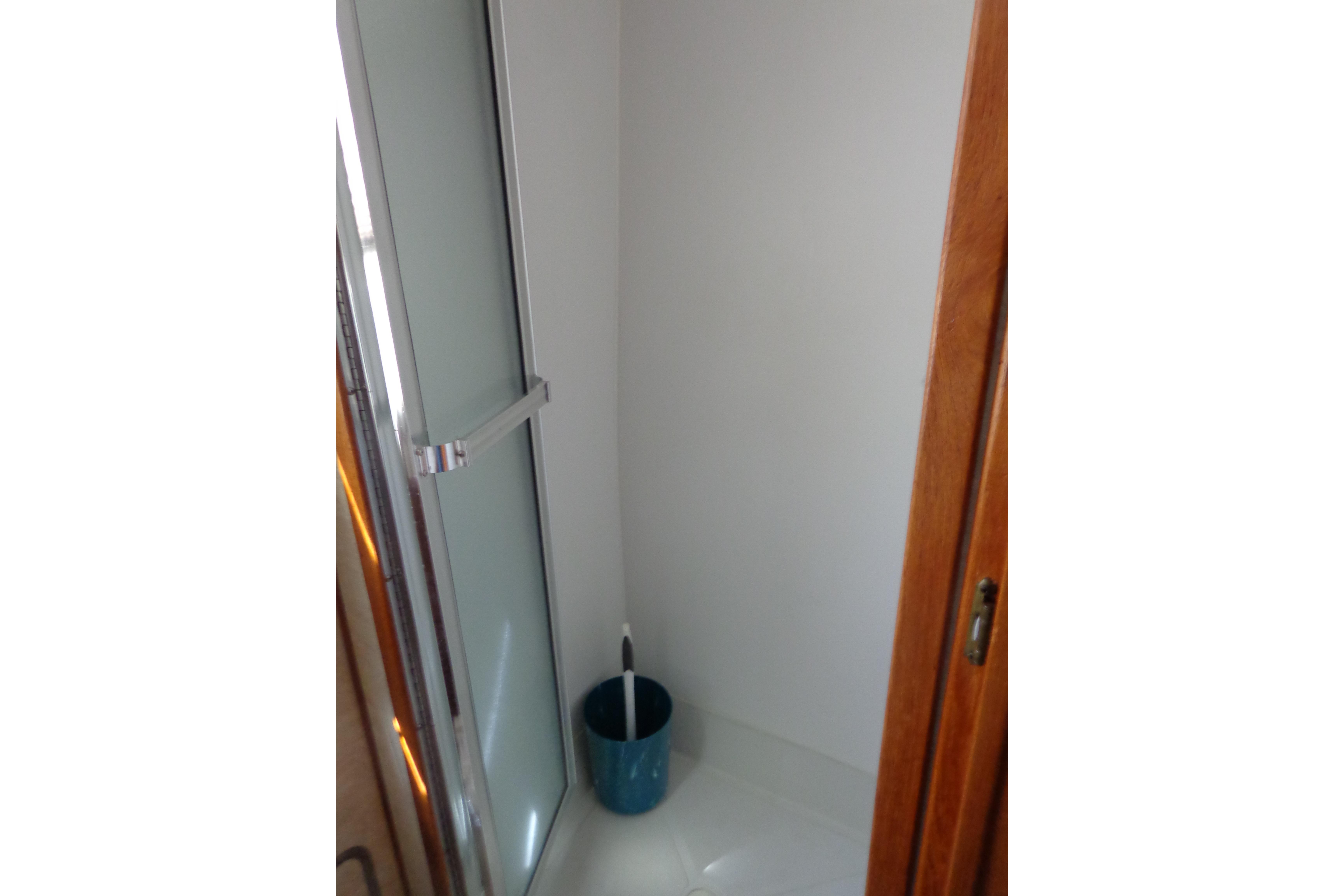 Shower area inside 1992 Cruise-A-Home Corsair 4200, featuring glass door and wooden trim.