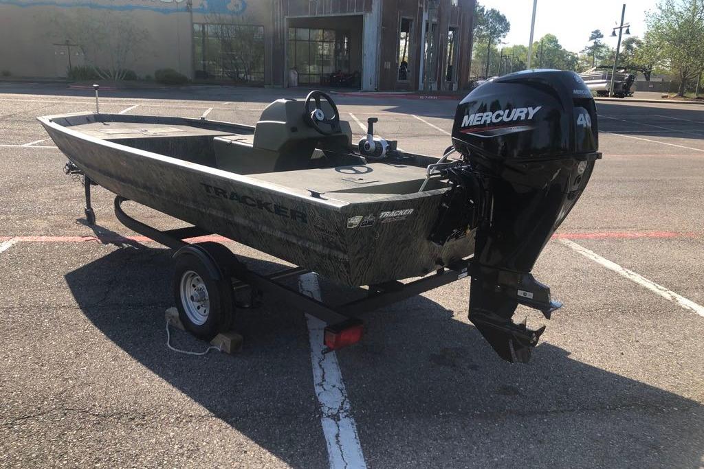 2026 Tracker Grizzly 1648 SC boat with Mercury engine on trailer in parking lot.
