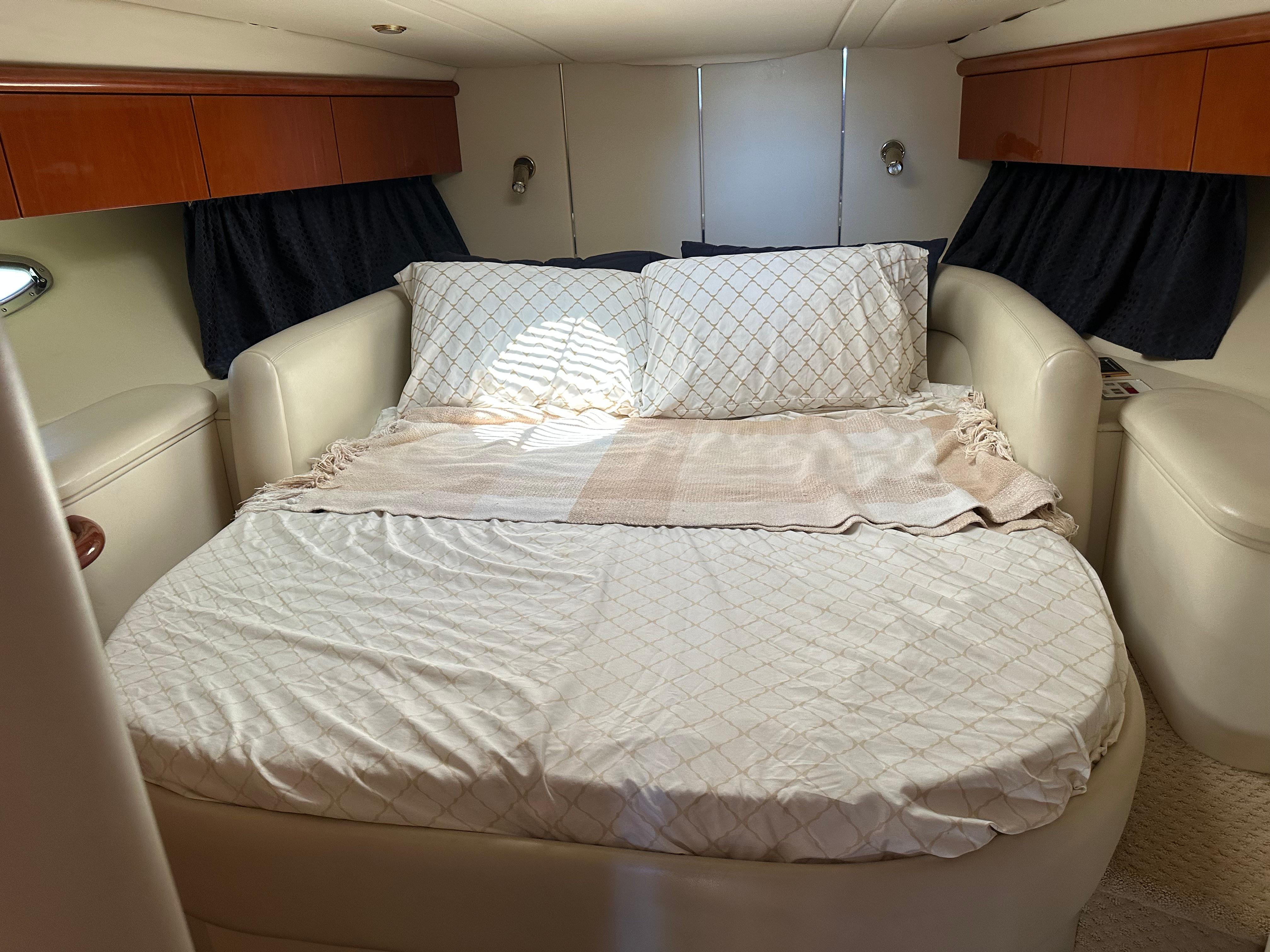 Luxurious bedroom interior of 1997 Sunseeker Camargue 47 yacht with cozy bedding.