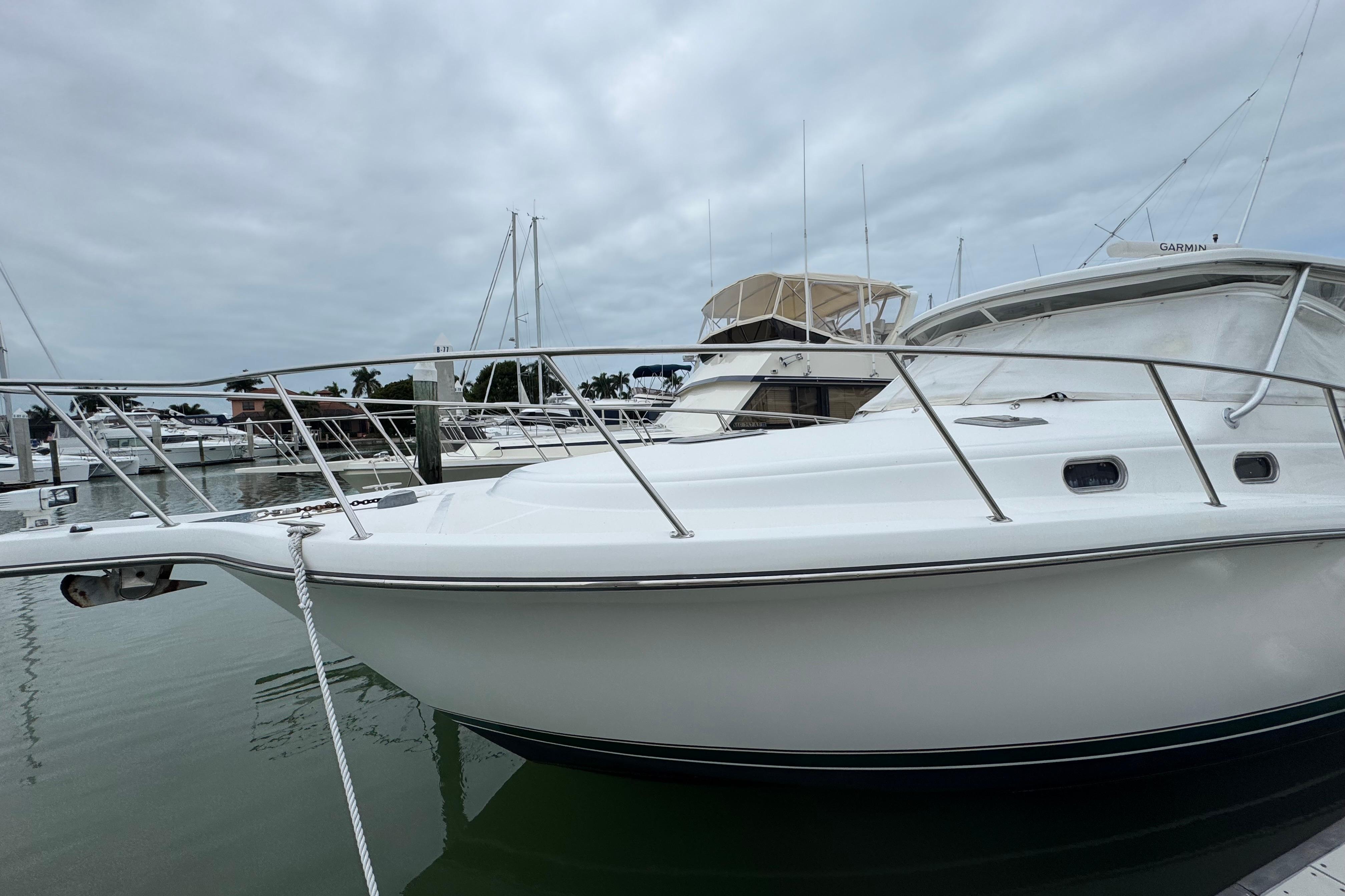 2002 Pursuit 3800 Express yacht docked in a marina under cloudy skies.