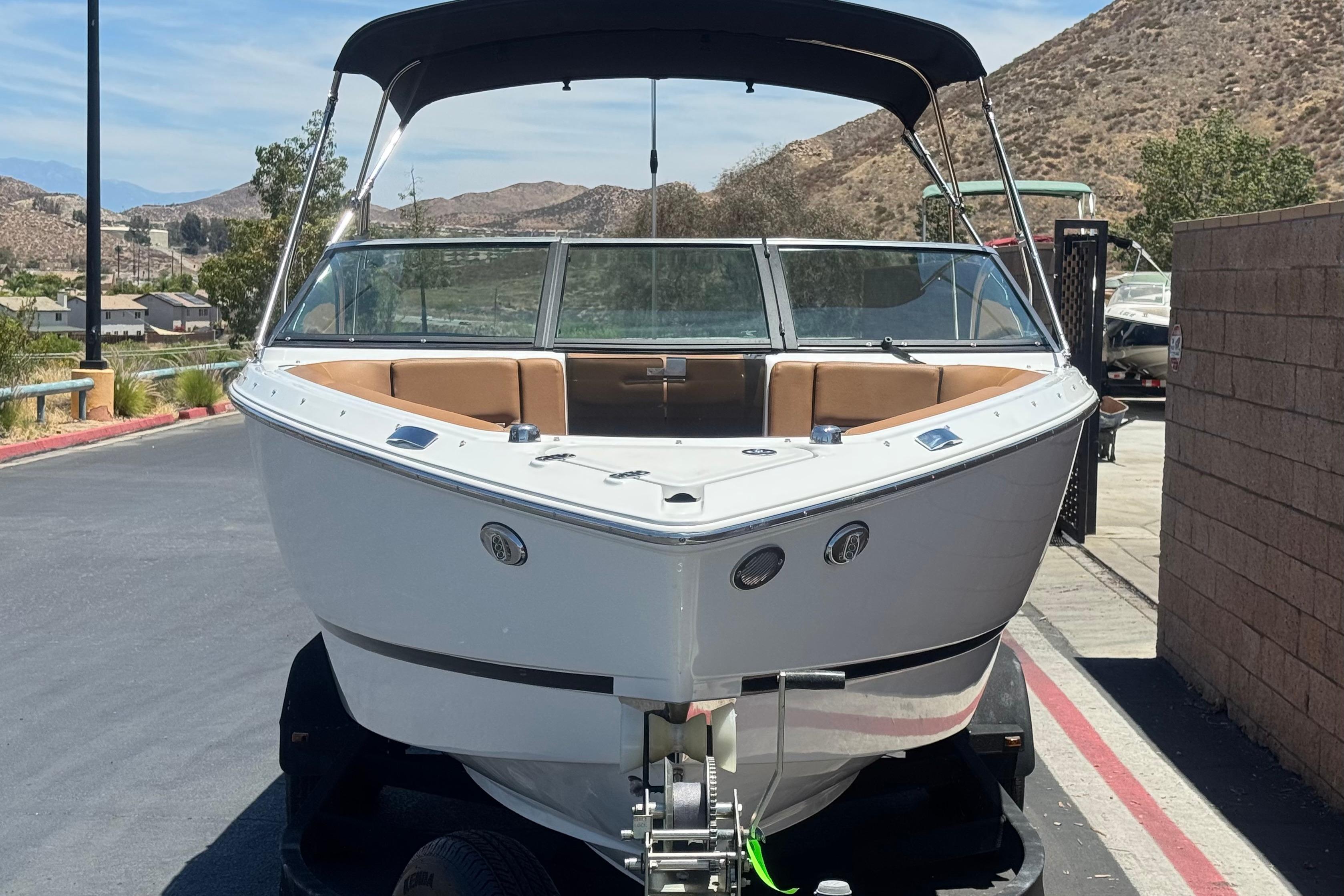 2022 Four Winns H4 boat on trailer, parked outdoors with scenic mountain backdrop.