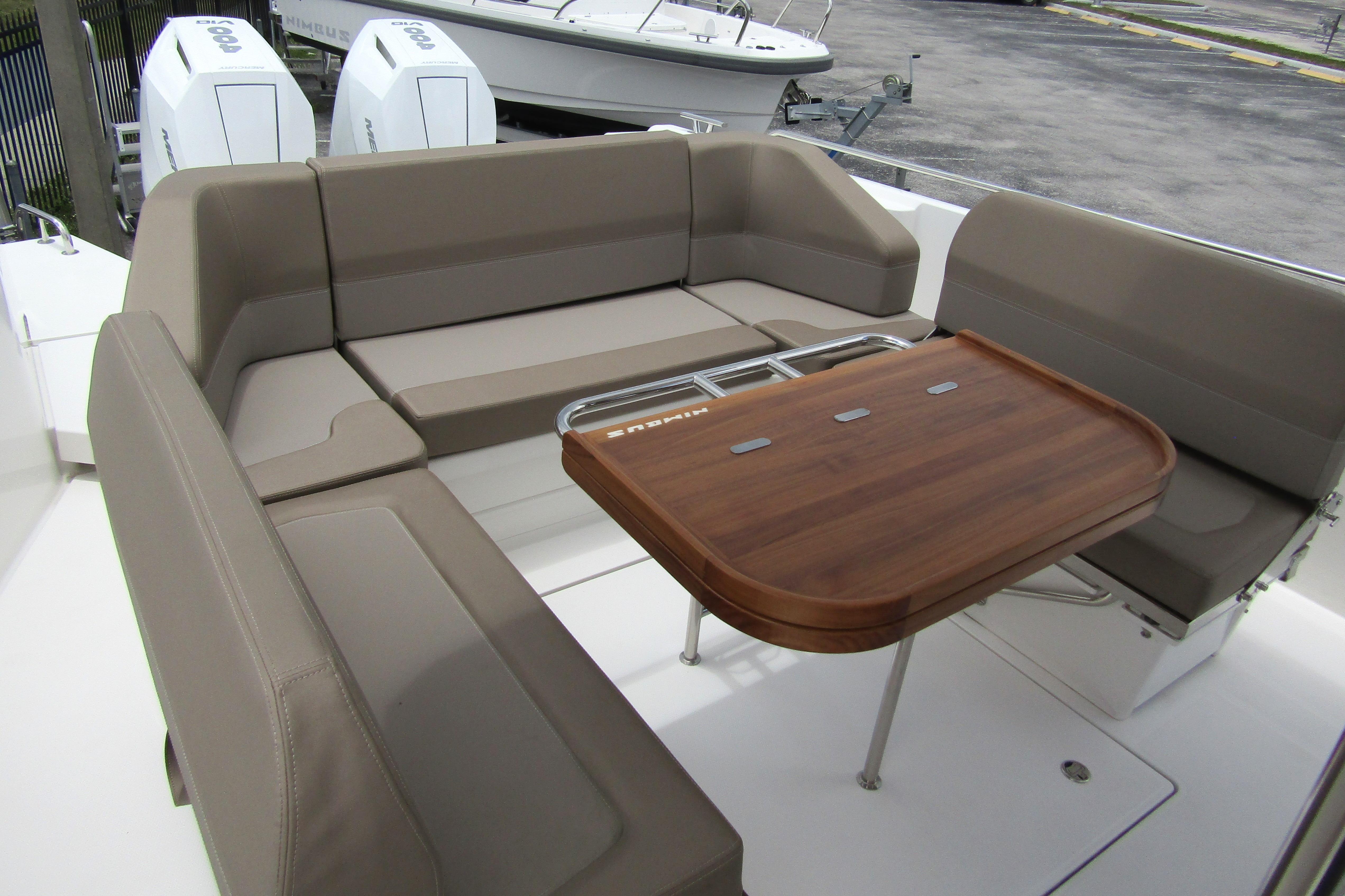 Luxurious seating area on 2025 Nimbus Tender 11 boat with wooden table.