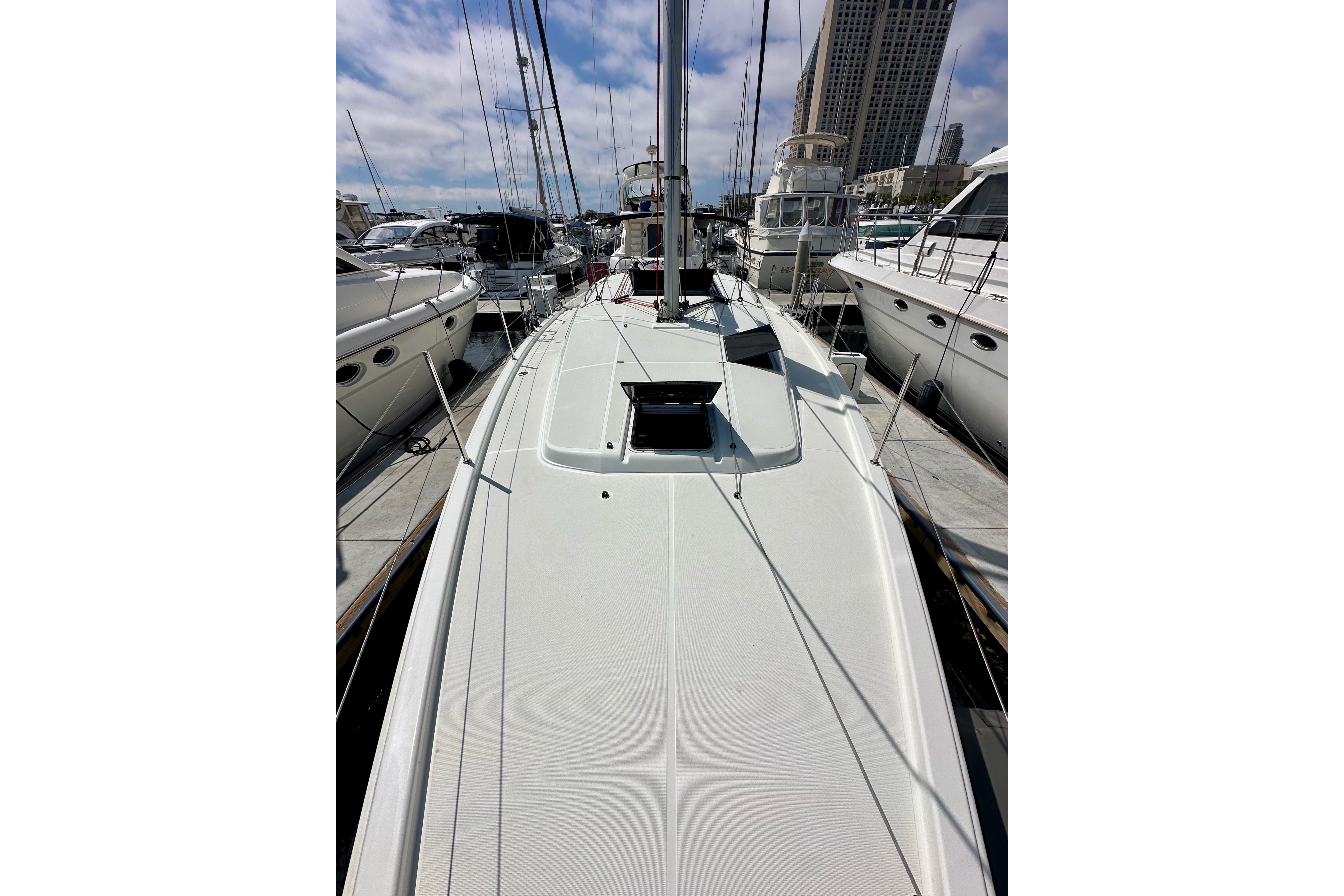 2024 Jeanneau Sun Odyssey 410 sailboat docked in a marina, surrounded by other boats.