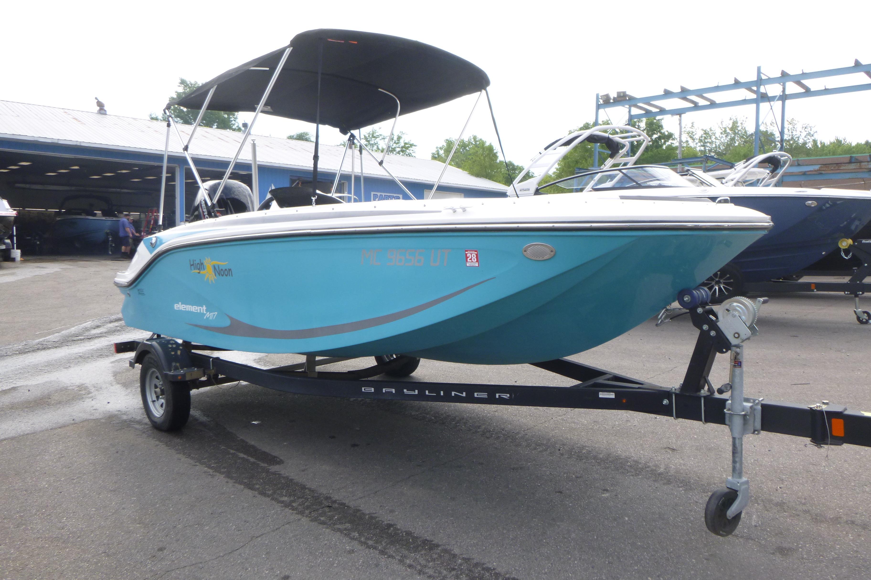 2022 Bayliner Element M17 boat on trailer, blue hull, parked outdoors.