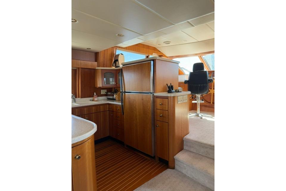 Luxurious interior of 1999 Wendon Skylounge 630 yacht with wooden cabinetry and modern amenities.