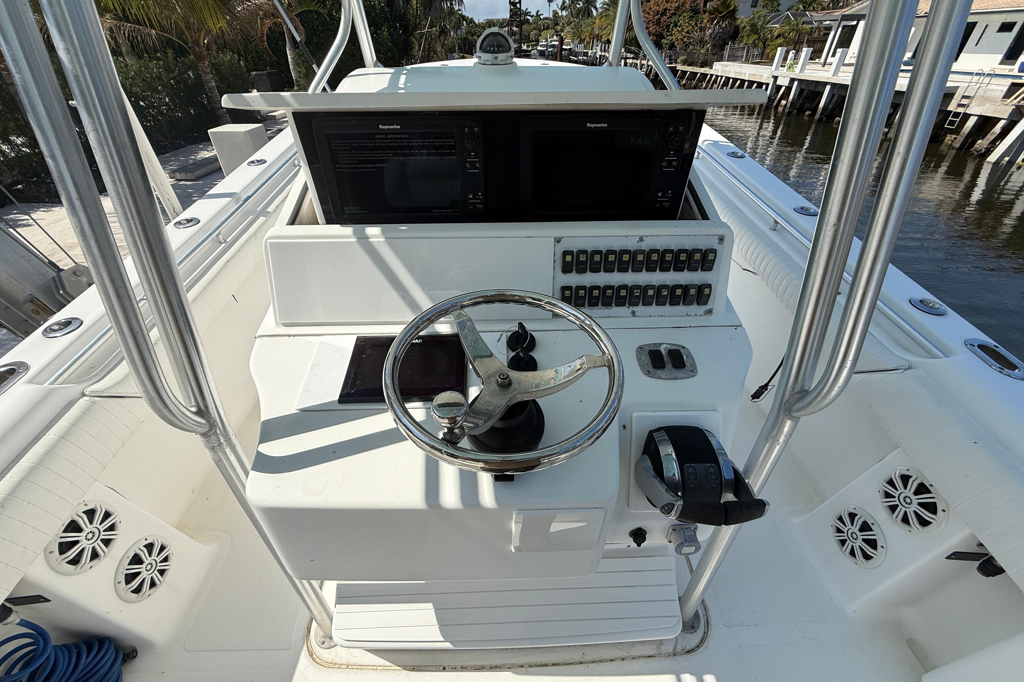 Steering console of 2003 Palmetto 33 Adventure boat with controls and navigation screens.