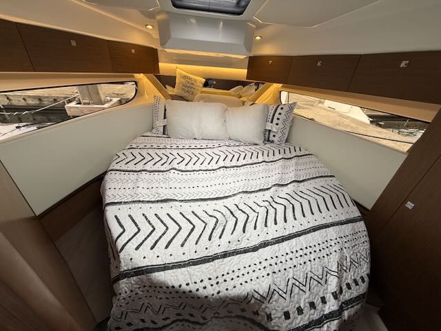 The image shows a cozy cabin with a double bed and modern wood accents.