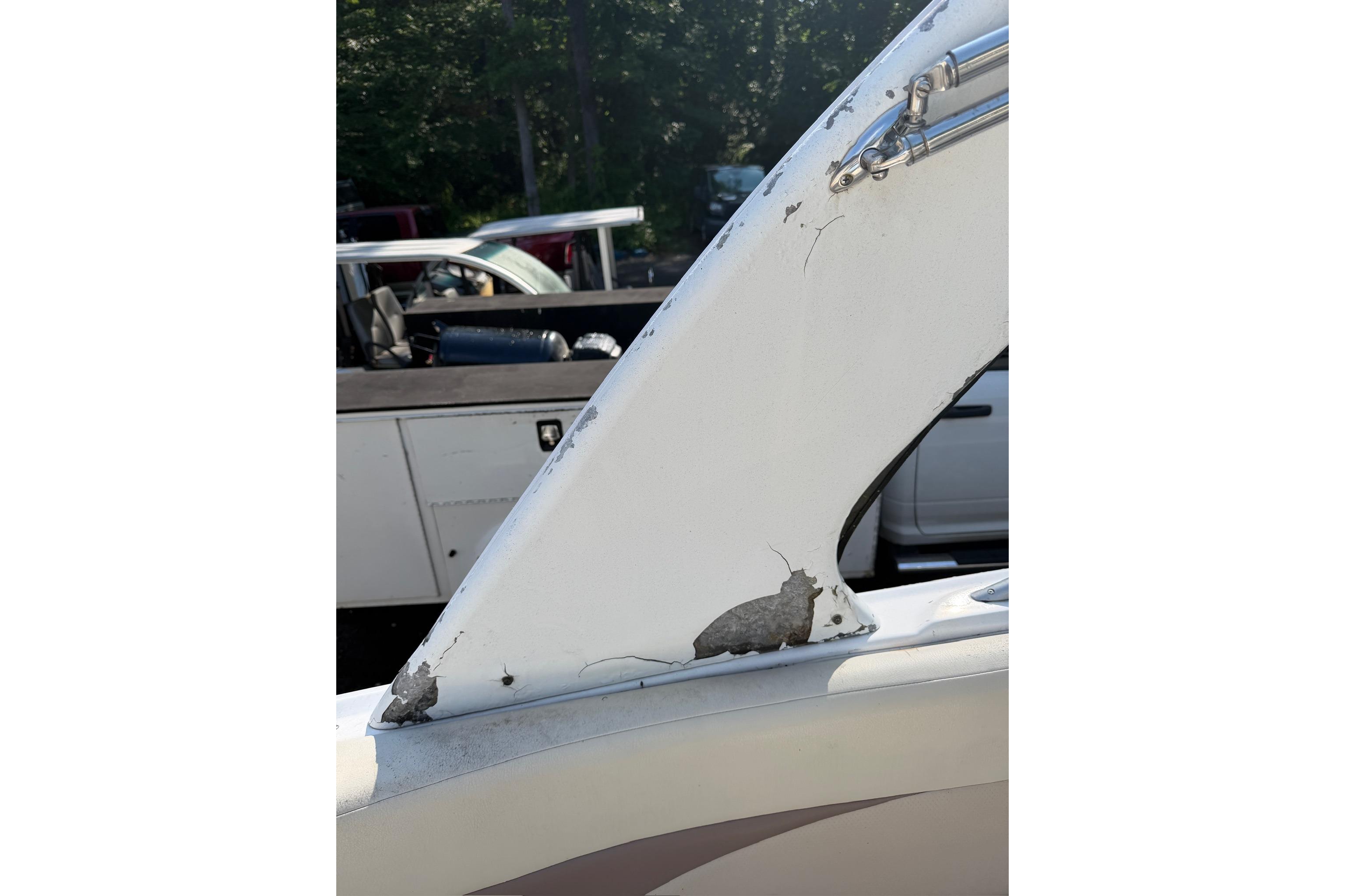 2005 Chaparral 256 SSi boat with visible wear and damage on the hull.