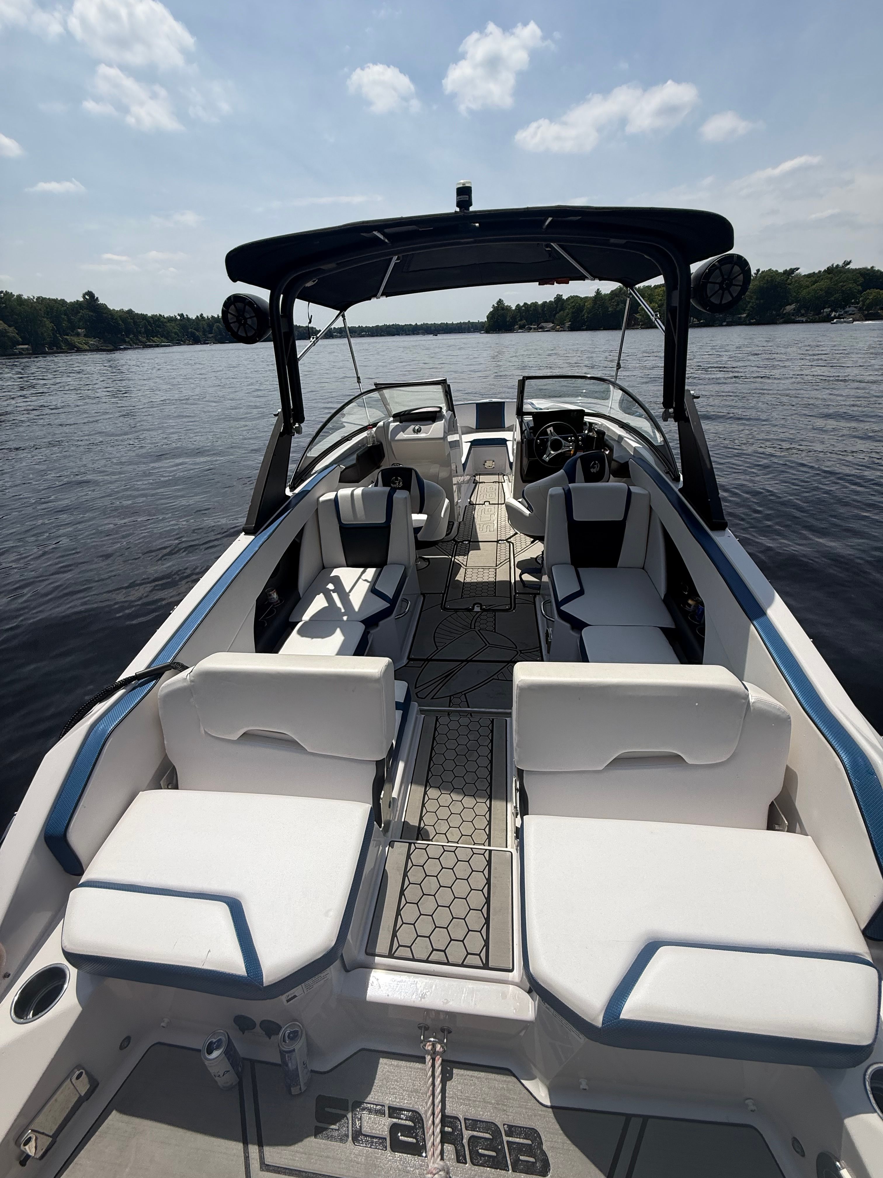 2018 Scarab 255 HOI on a calm lake, featuring modern design and comfortable seating.