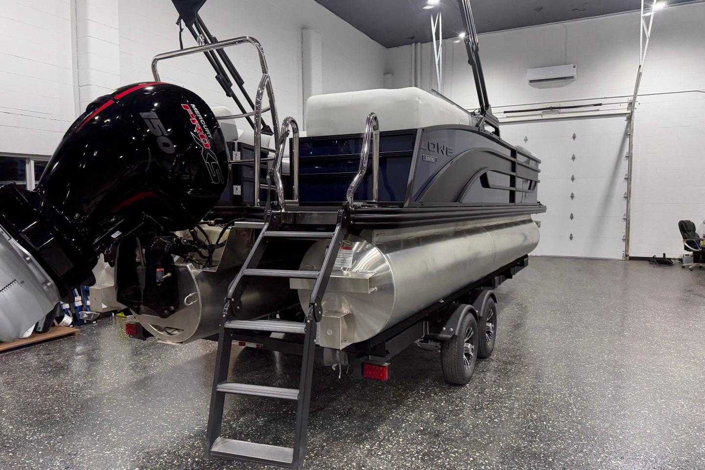 2026 Lowe SS 230 WT pontoon boat in showroom, featuring powerful outboard motor.