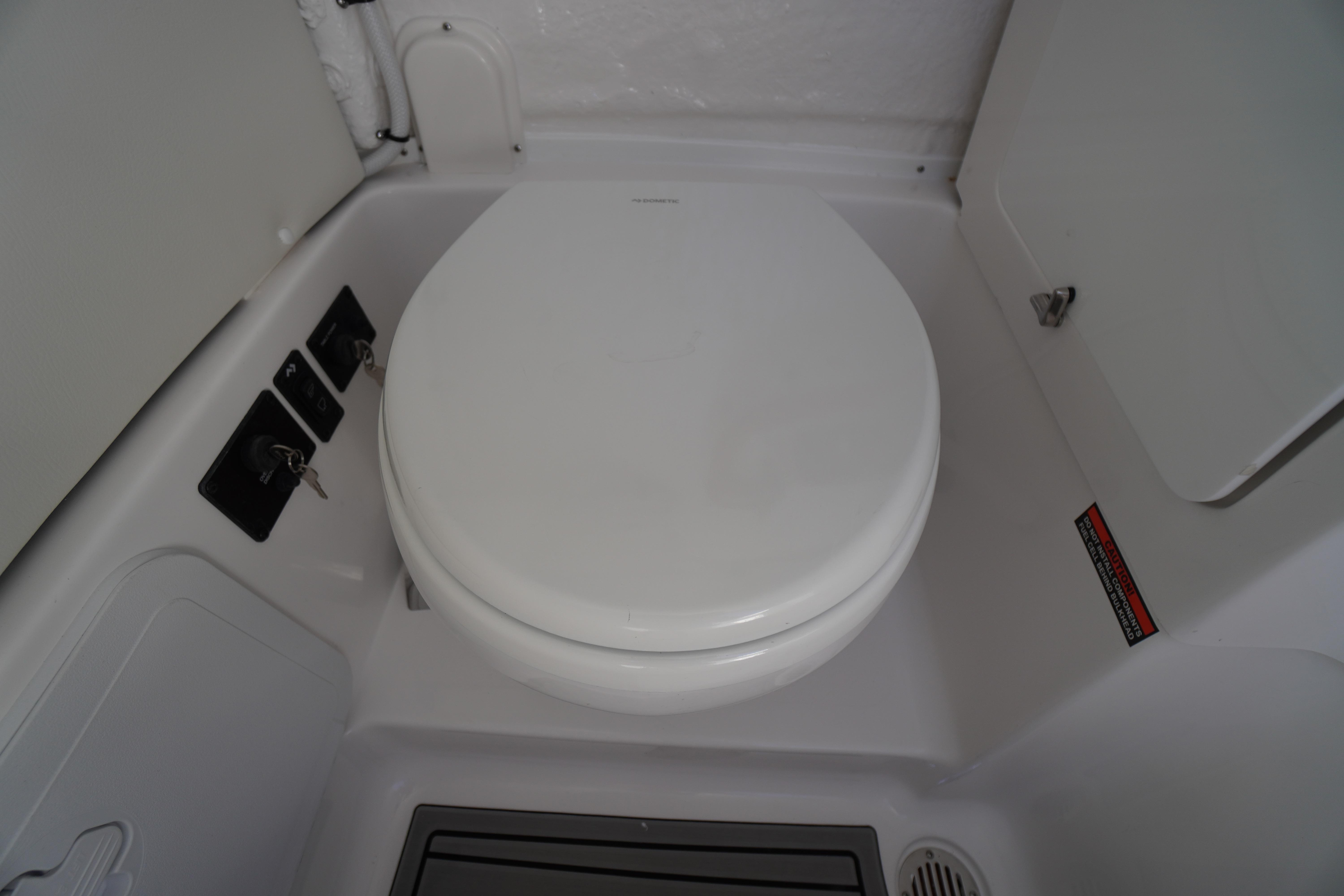 2026 Tidewater 272 LXF boat interior with a compact marine toilet.