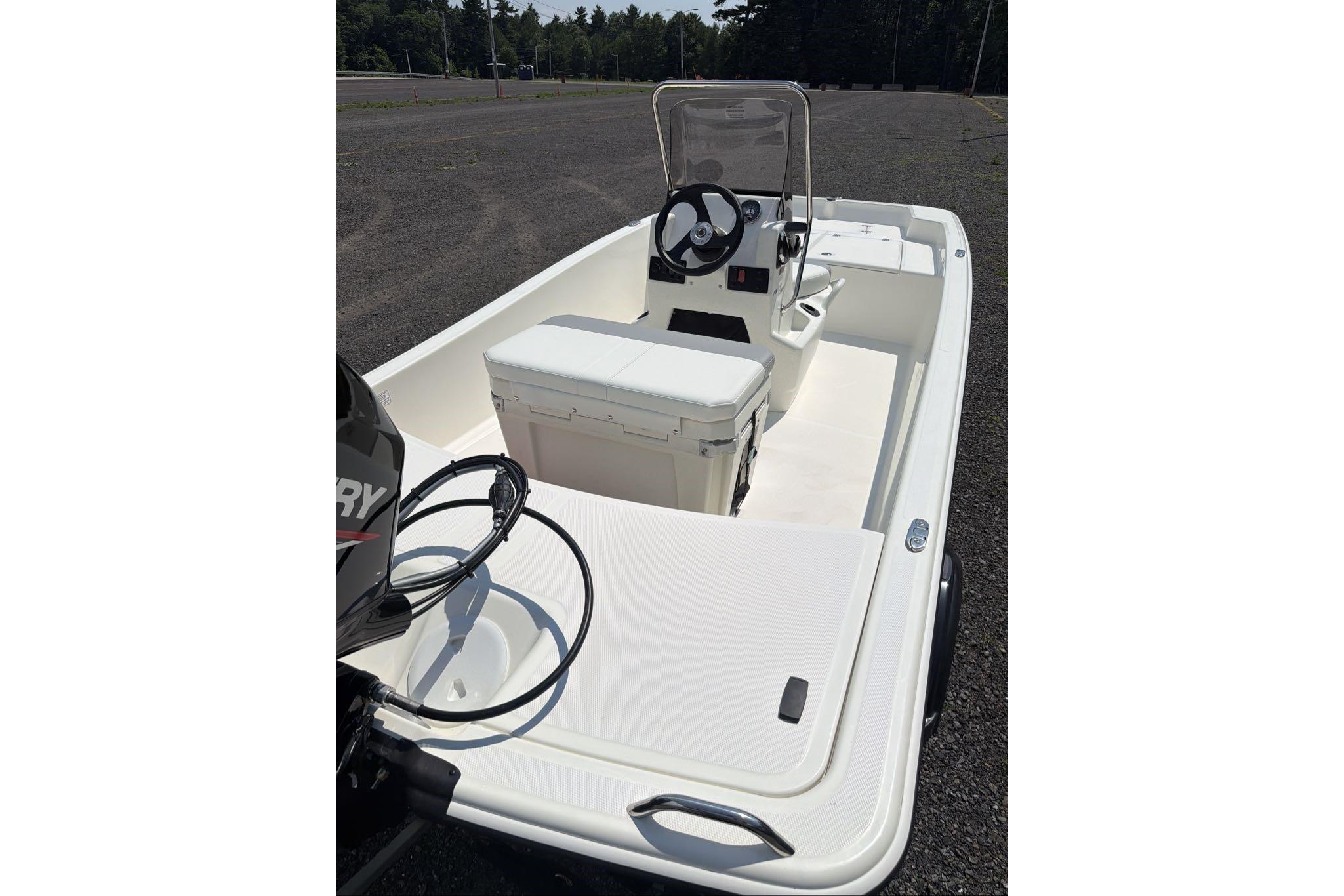 2026 Mako Pro Skiff 15 CC boat with center console and outboard motor.