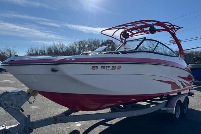 2020 Yamaha Boats 242X E-Series on trailer, red and white design, parked outdoors.