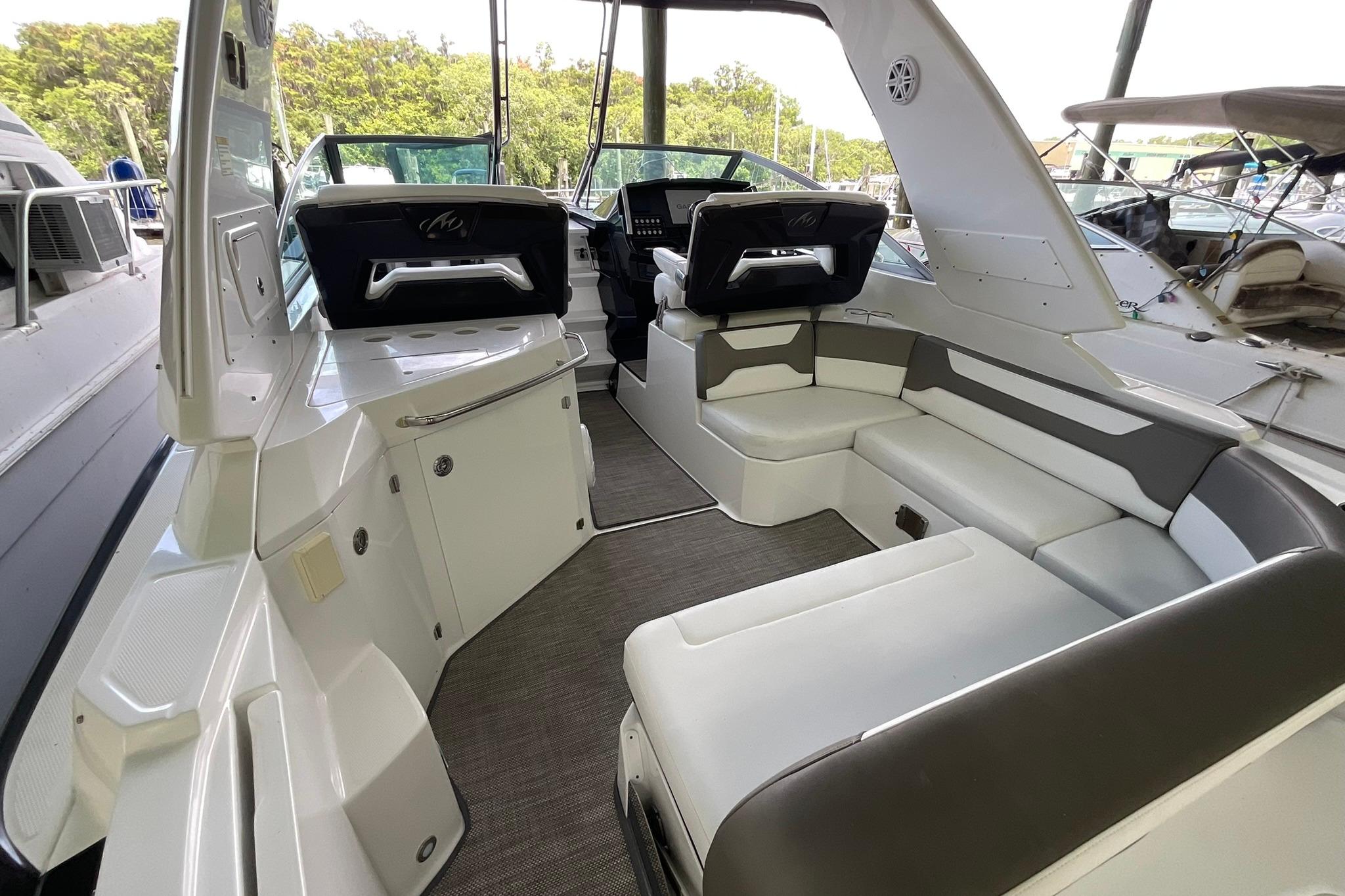 2019 Monterey 335 Sport Yacht interior with seating and helm, docked at marina.
