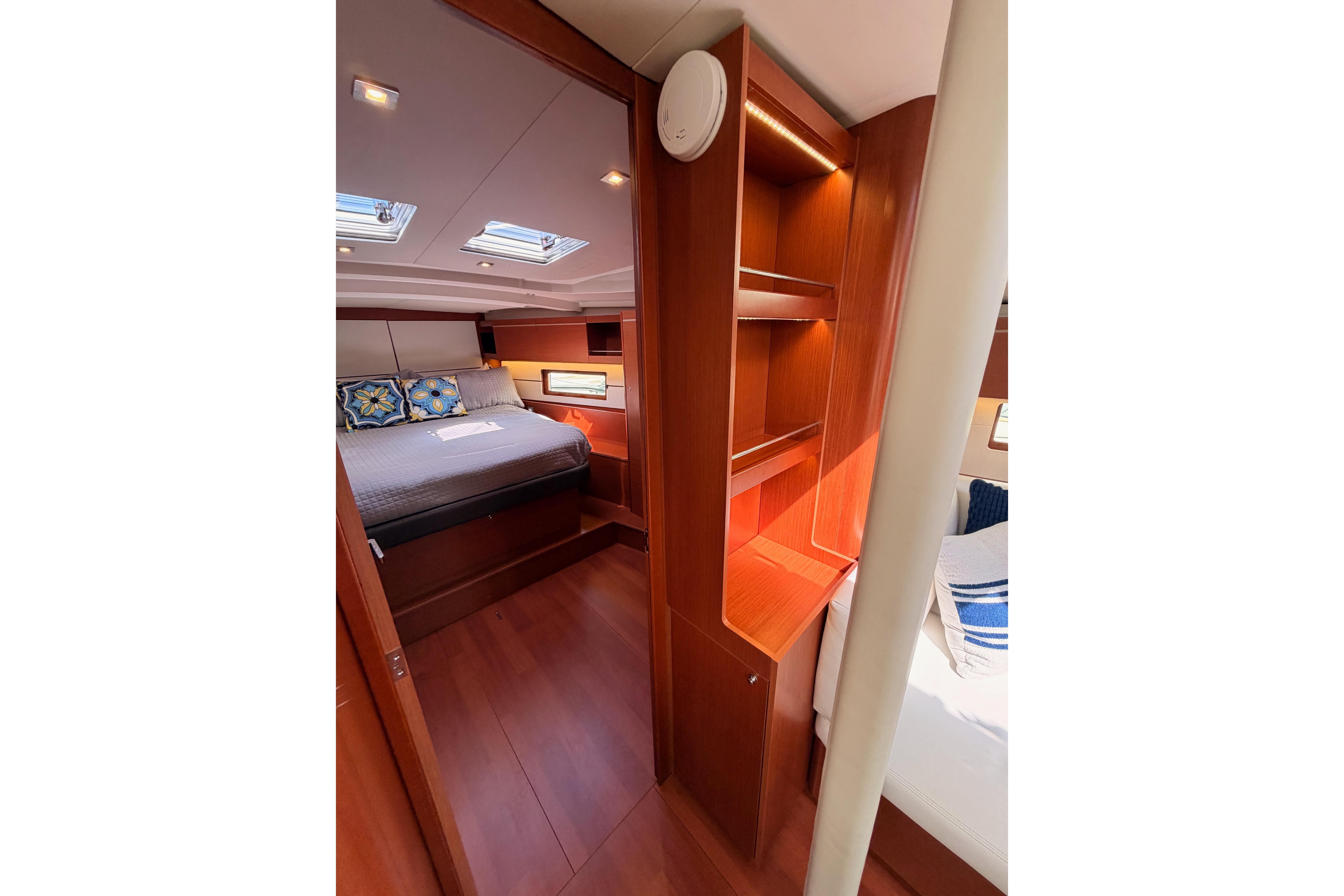 Luxurious interior of 2020 Beneteau Oceanis 46.1 yacht with cozy bedroom and wooden furnishings.