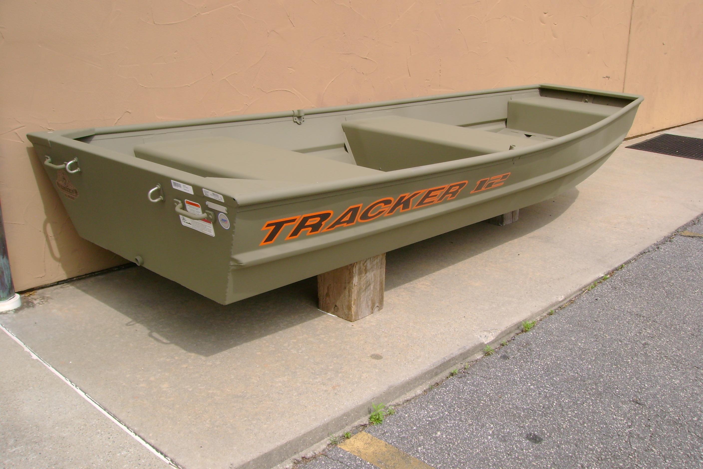 2026 Tracker Grizzly 12 Jon boat in olive green, displayed outdoors on a concrete surface.