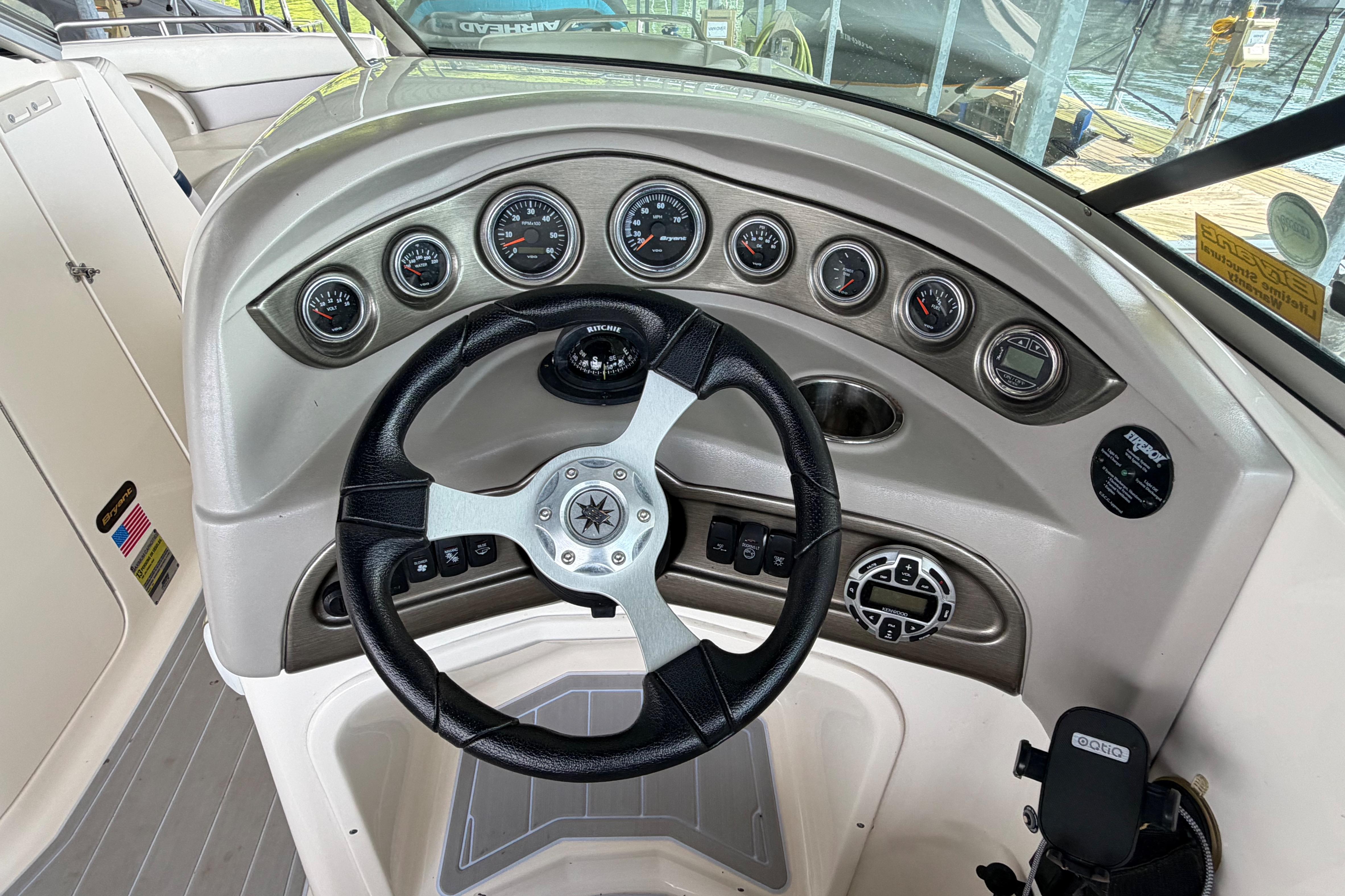 Steering wheel and dashboard of a 2010 Bryant 255 boat with gauges and controls.