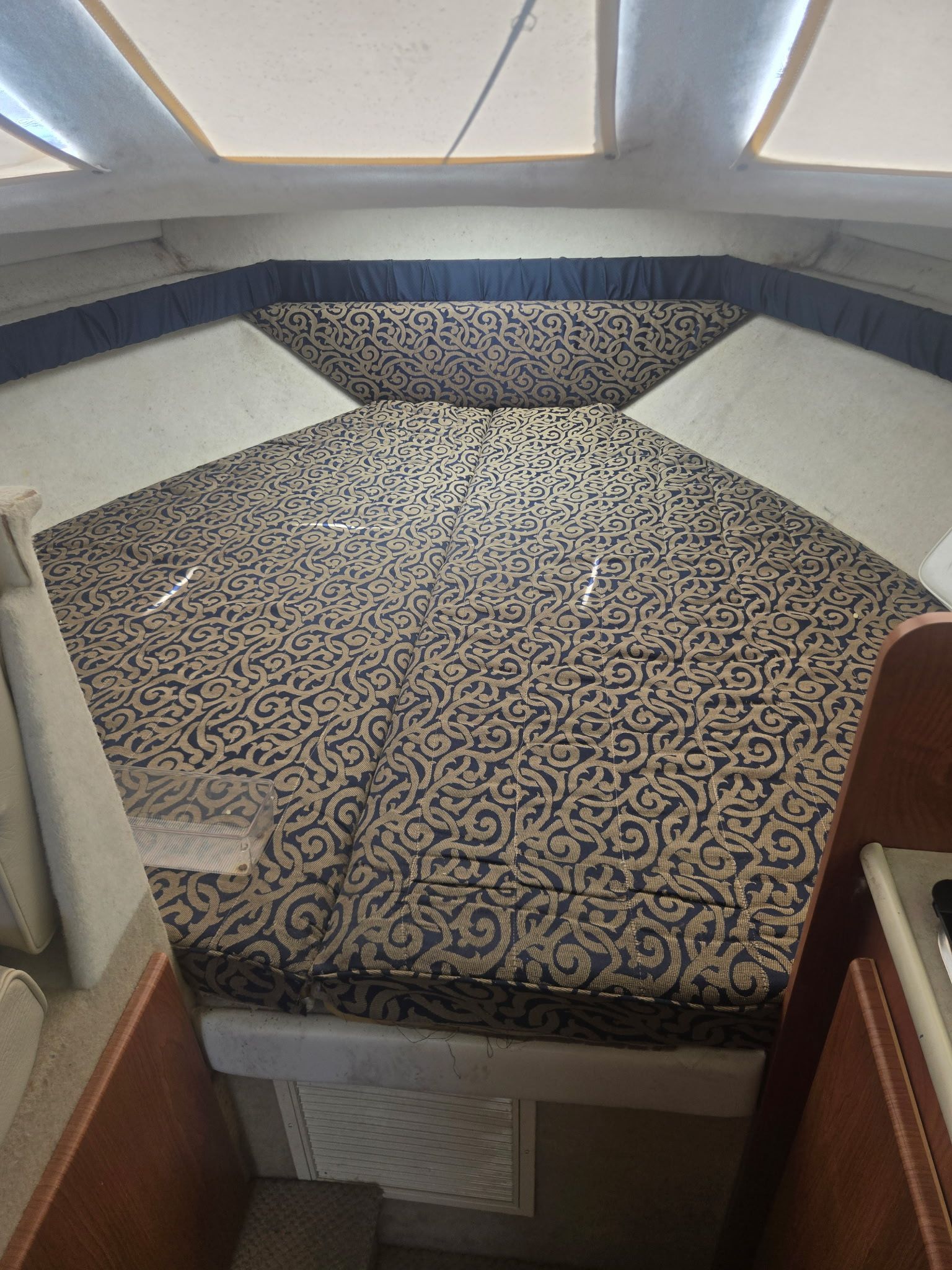 Interior of a 2003 Bayliner 28 with patterned bedding.