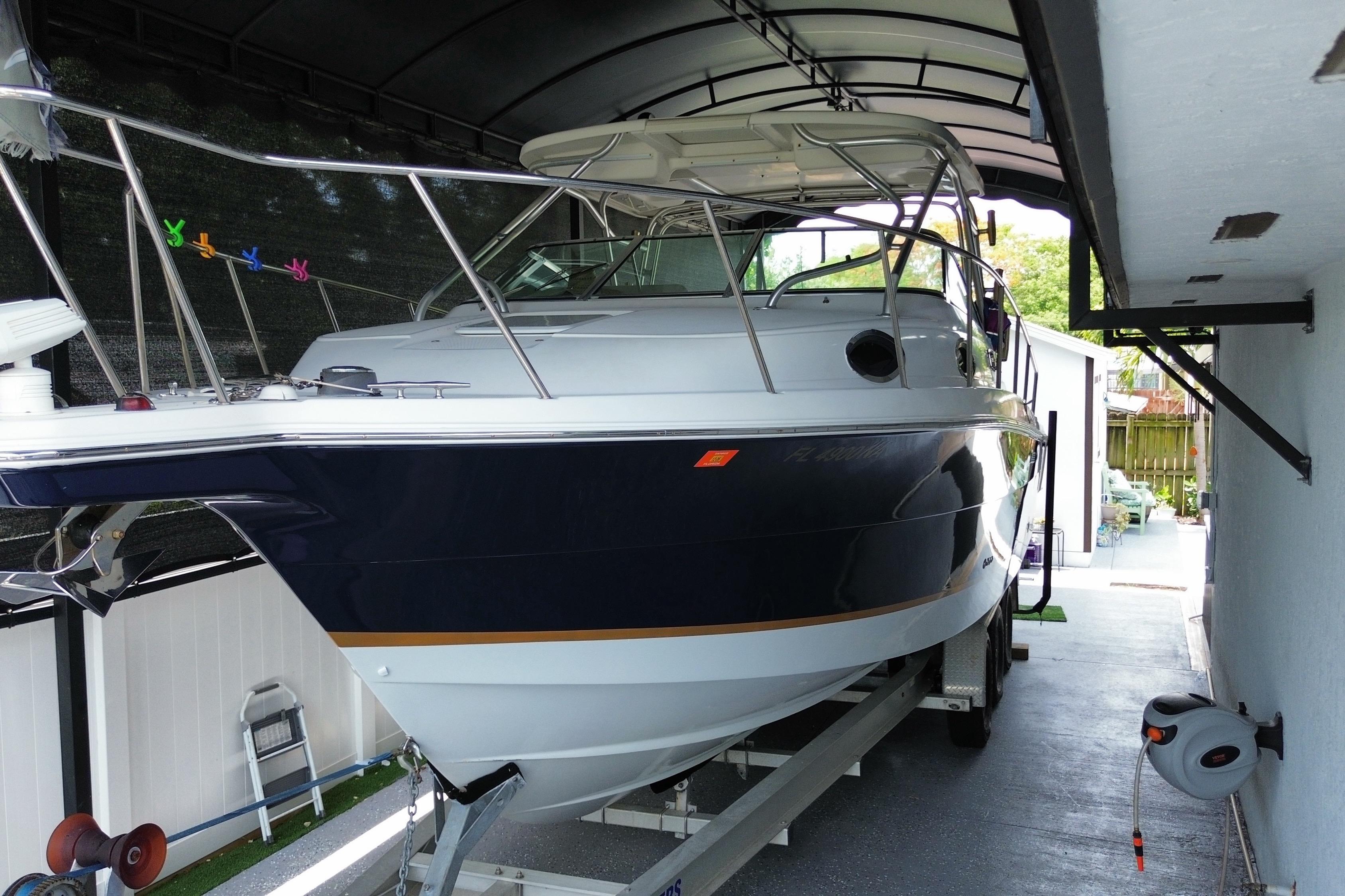 2005 Wellcraft 290 Coastal boat on trailer under shelter.
