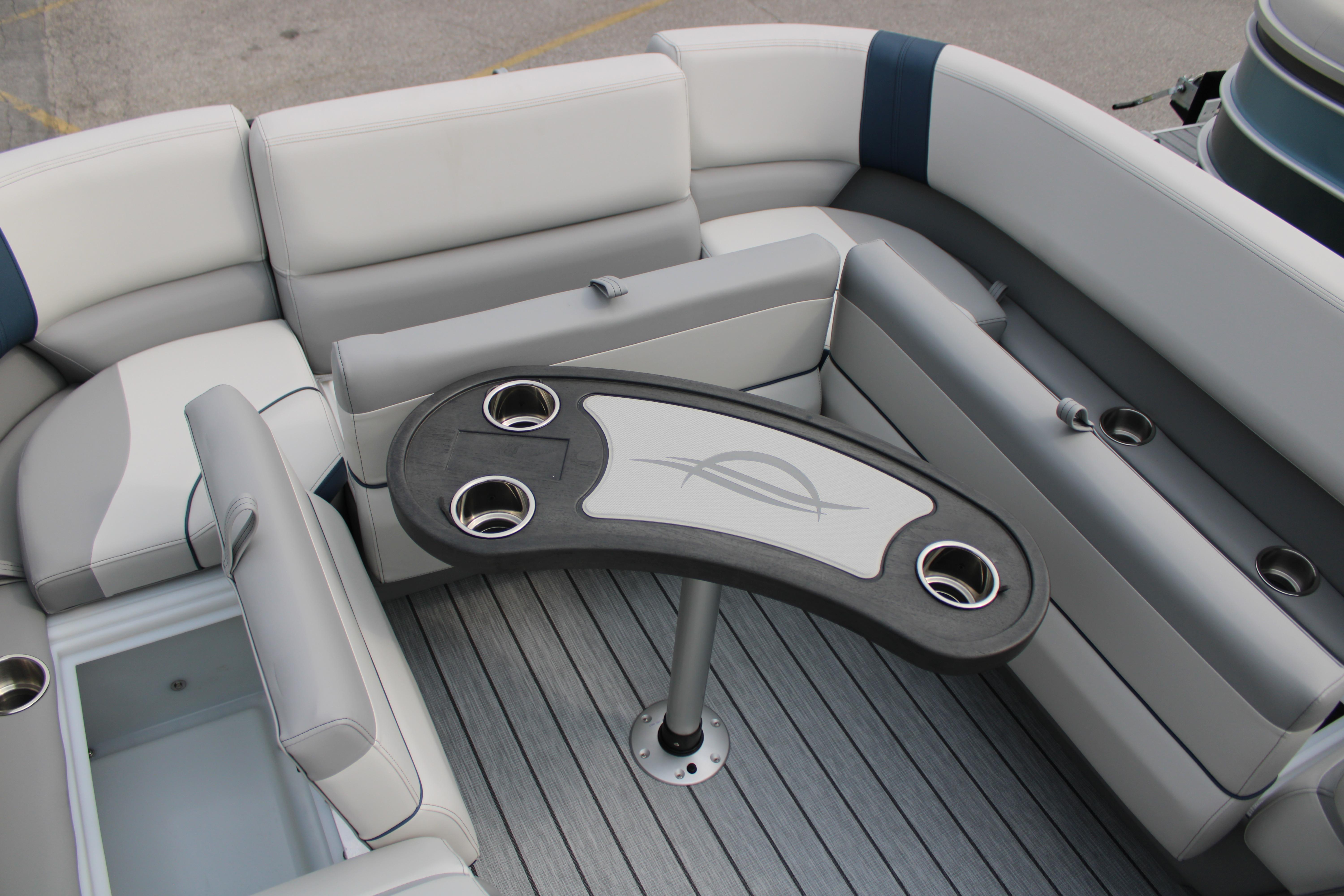 Luxurious seating area on 2025 SunCatcher Select 320RCX pontoon boat with cup holders.