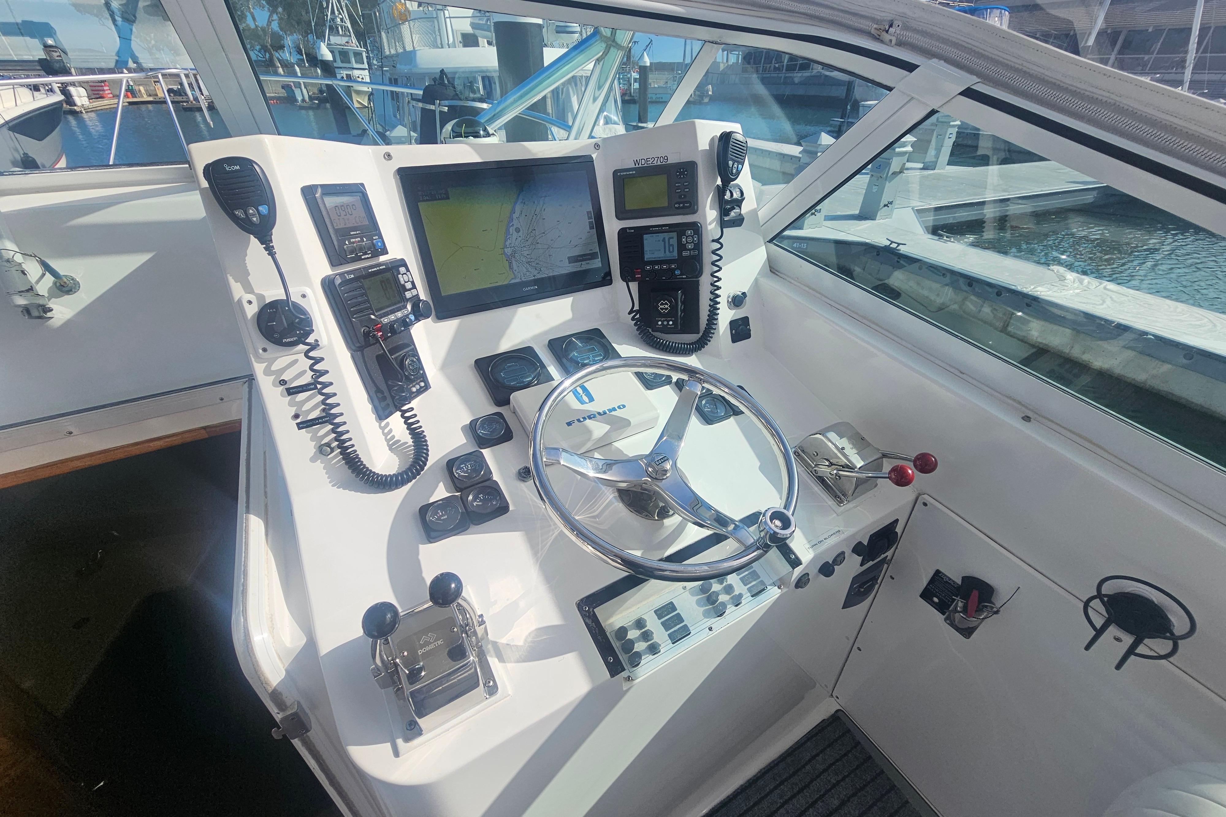 Cockpit of 2003 Topaz 32 Express boat with navigation equipment and steering wheel.