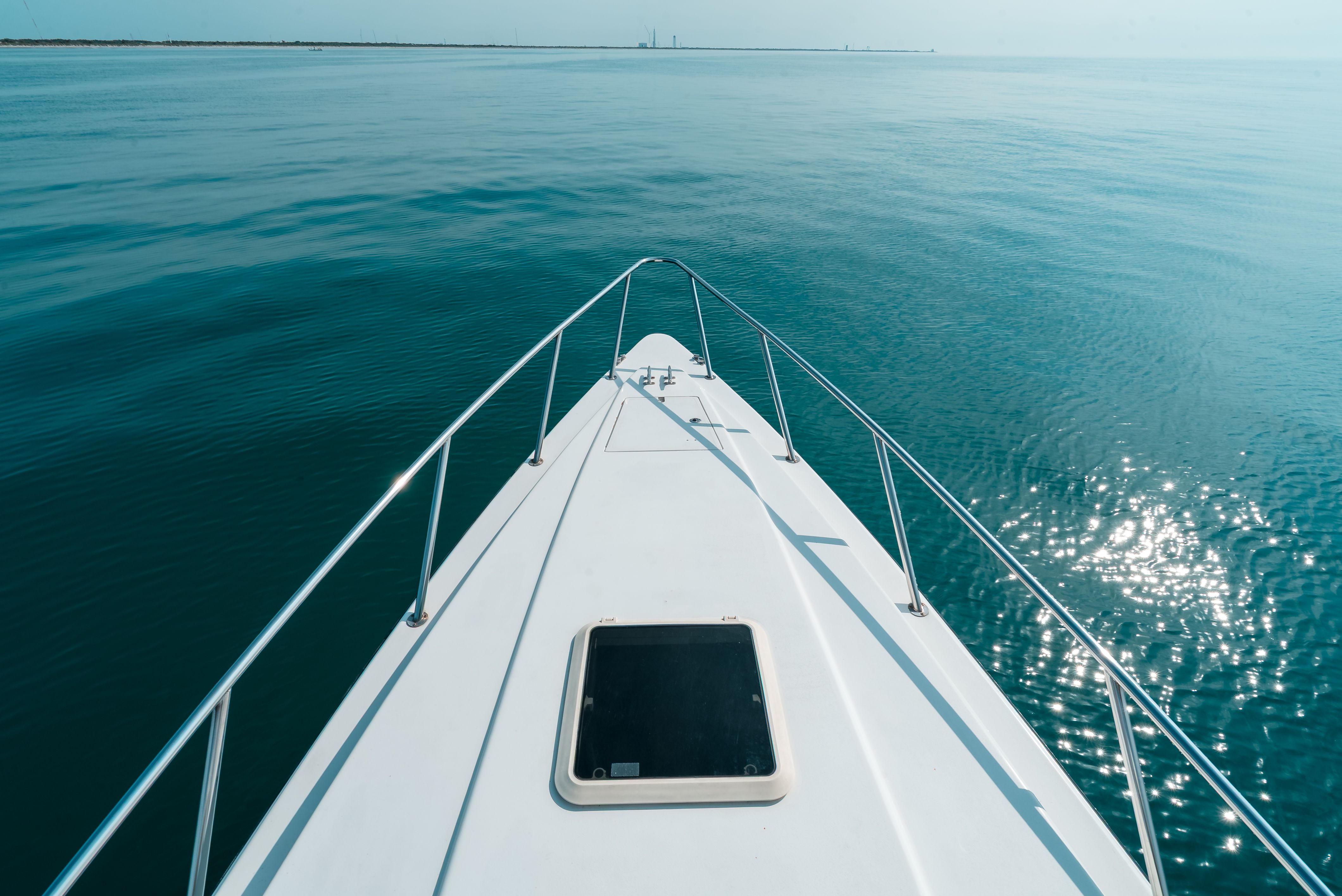Bow of a boat on calm water with a clear view of the horizon.