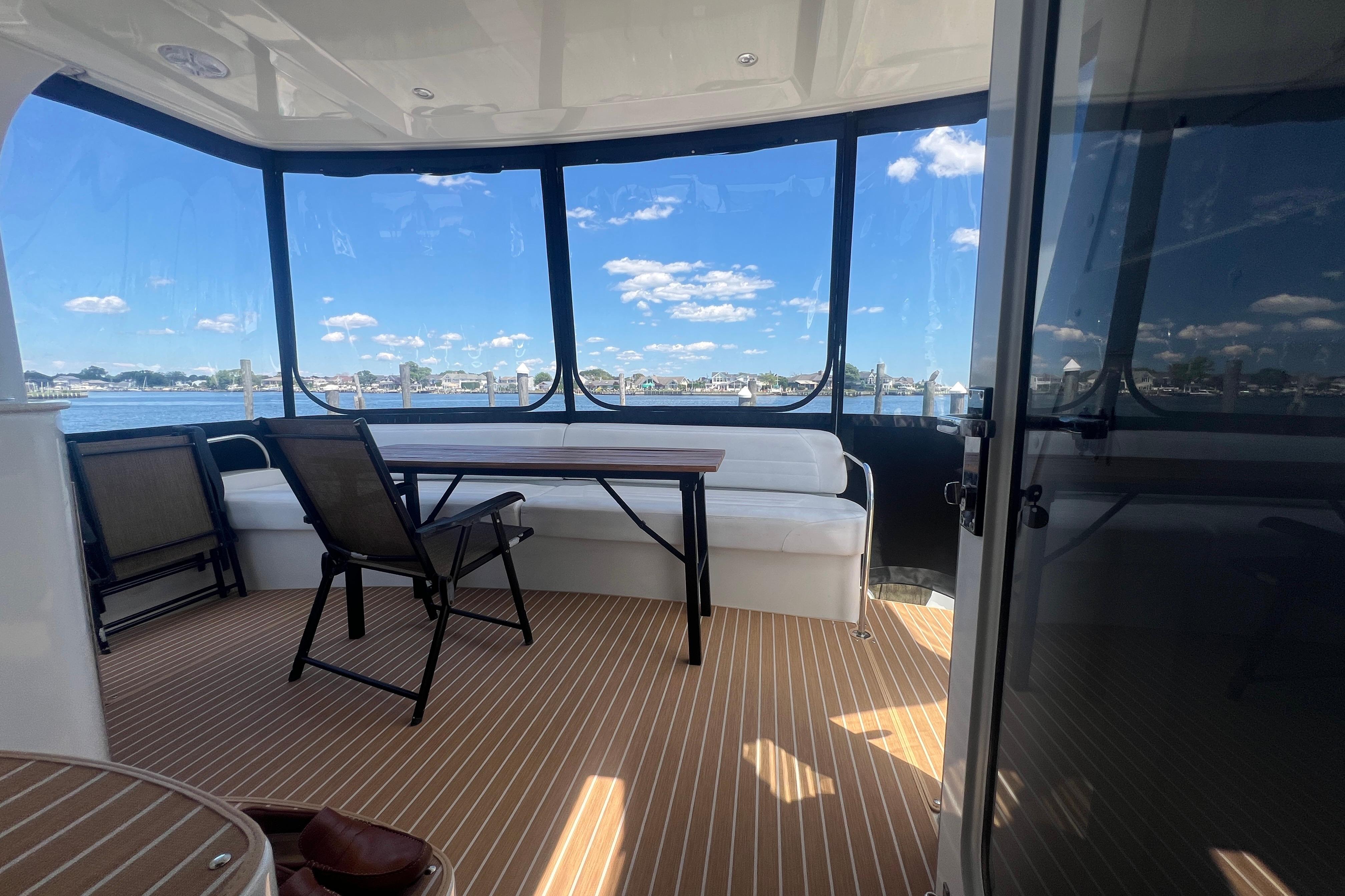 2006 Carver 43 Motor Yacht interior with seating, table, and scenic water view.