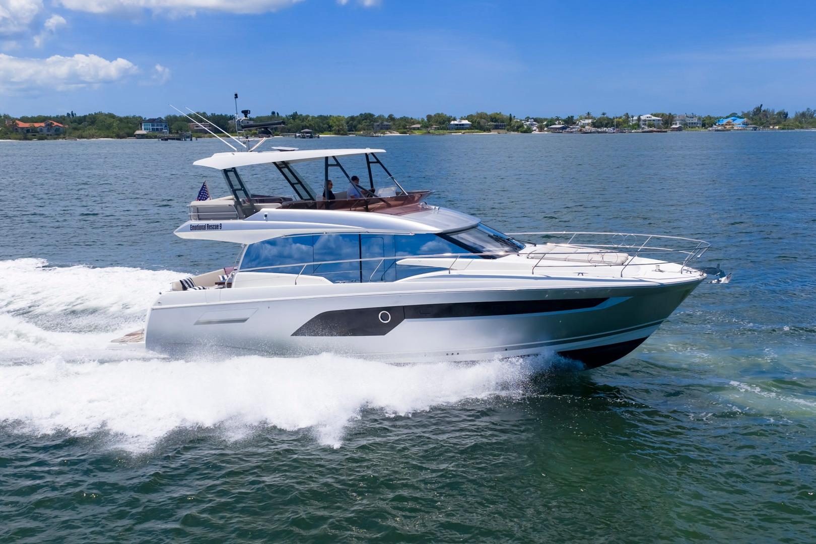 2022 Prestige 520 yacht cruising on open water under clear blue skies.