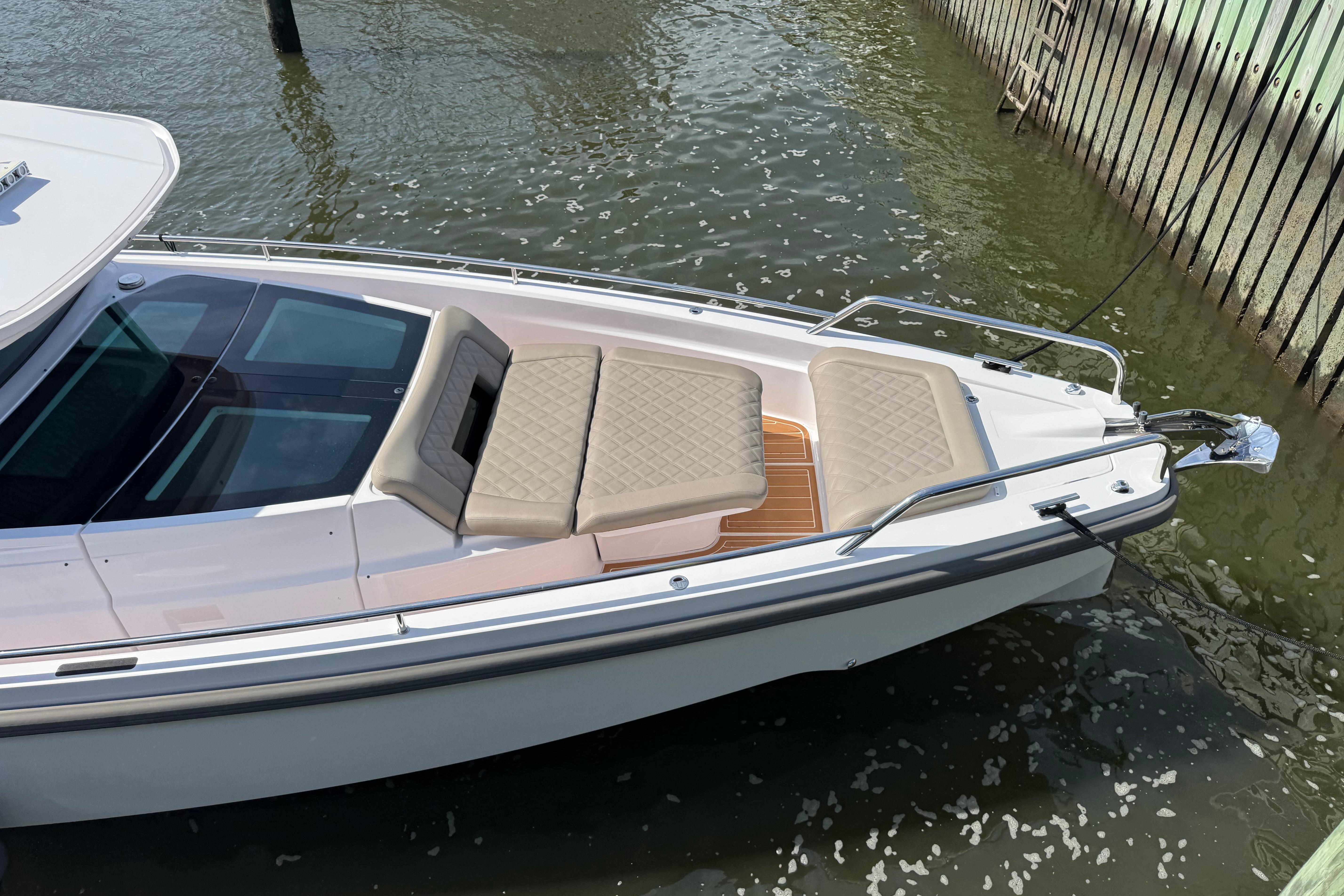 2022 Axopar 37 XC CROSS CABIN boat with cushioned seating, docked in water.