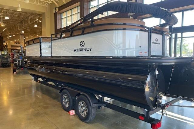 2026 Regency 230 DL pontoon boat displayed indoors on a trailer.