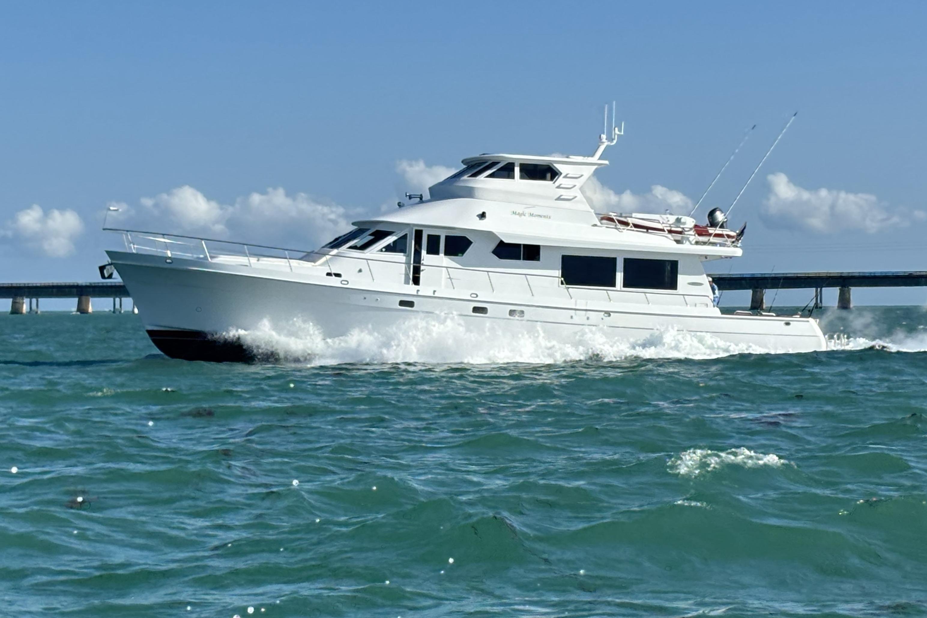 2006 Northstar 73 Cockpit Motoryacht cruising on open water, bridge in background.