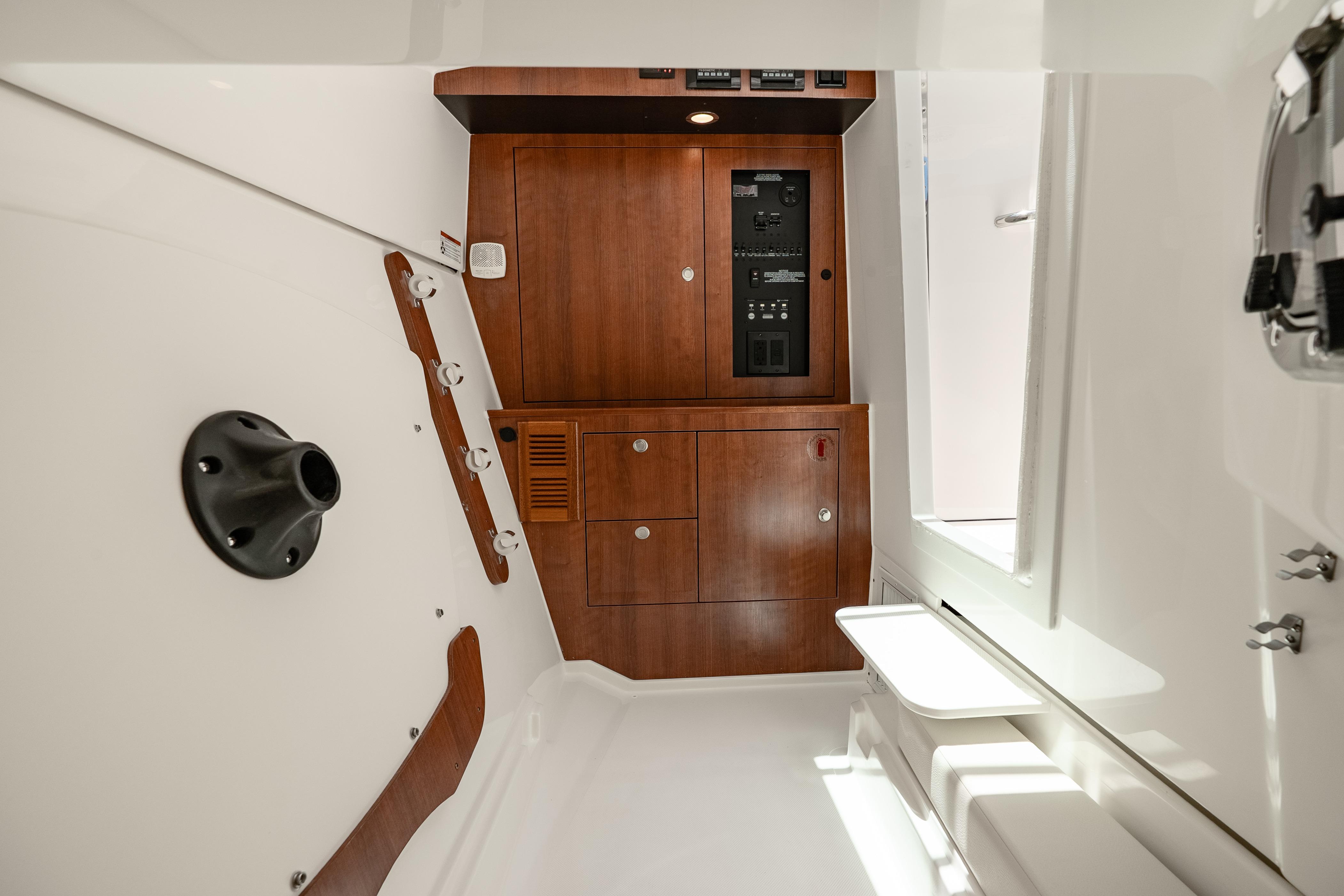 Interior of 2026 Pursuit DC 326 Dual Console, featuring wood cabinetry and control panel.