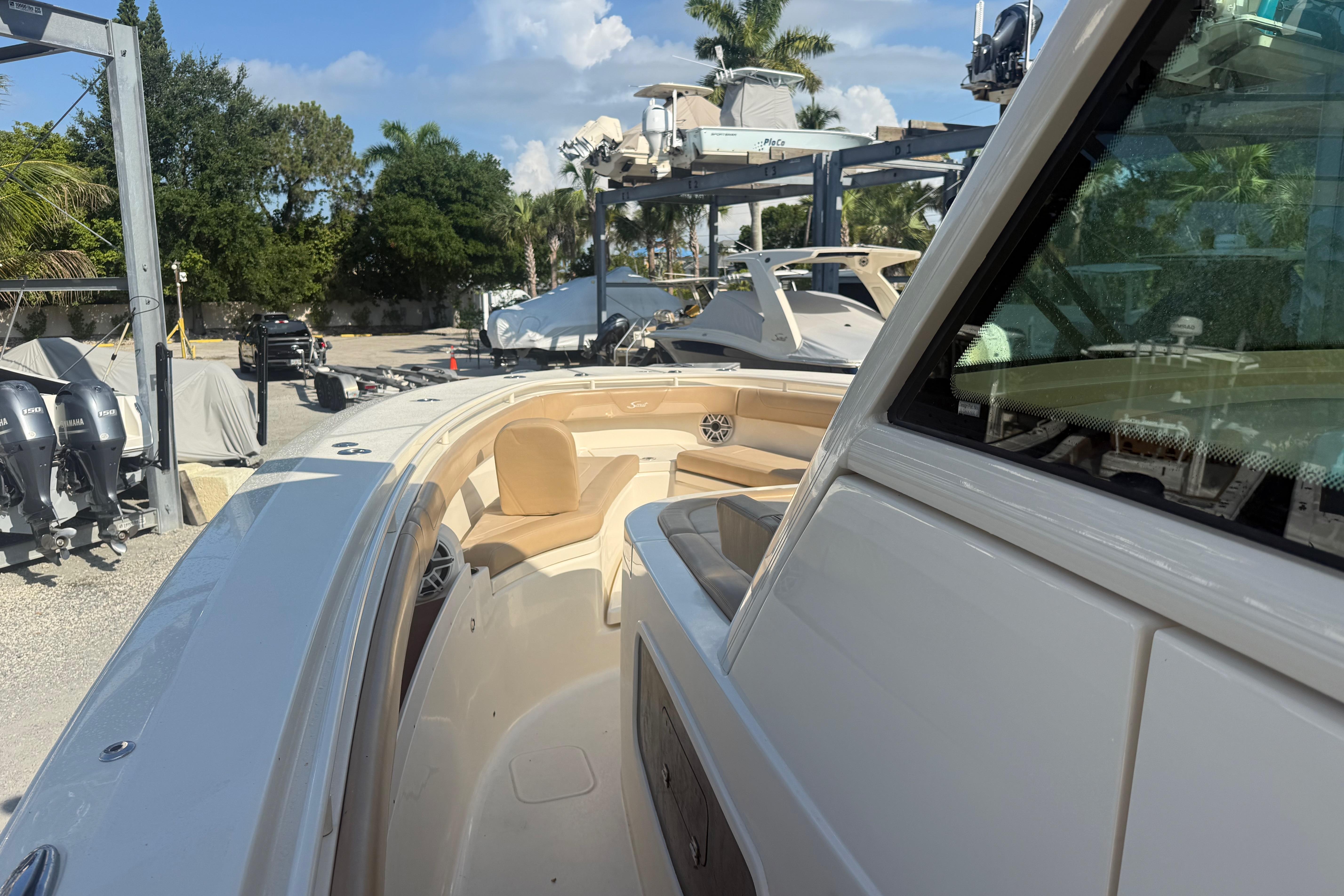 2022 Scout 355 LXF boat with sleek design and luxurious seating in a marina setting.