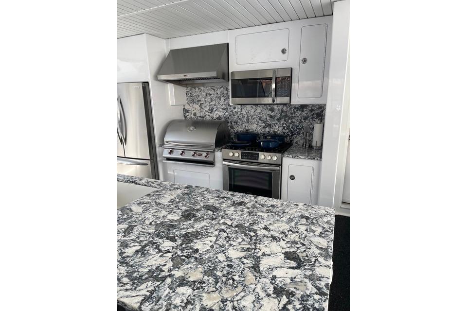 Modern kitchen with stainless steel appliances and marble countertops on Adonia's 2021 model, The Queen Elizabeth.
