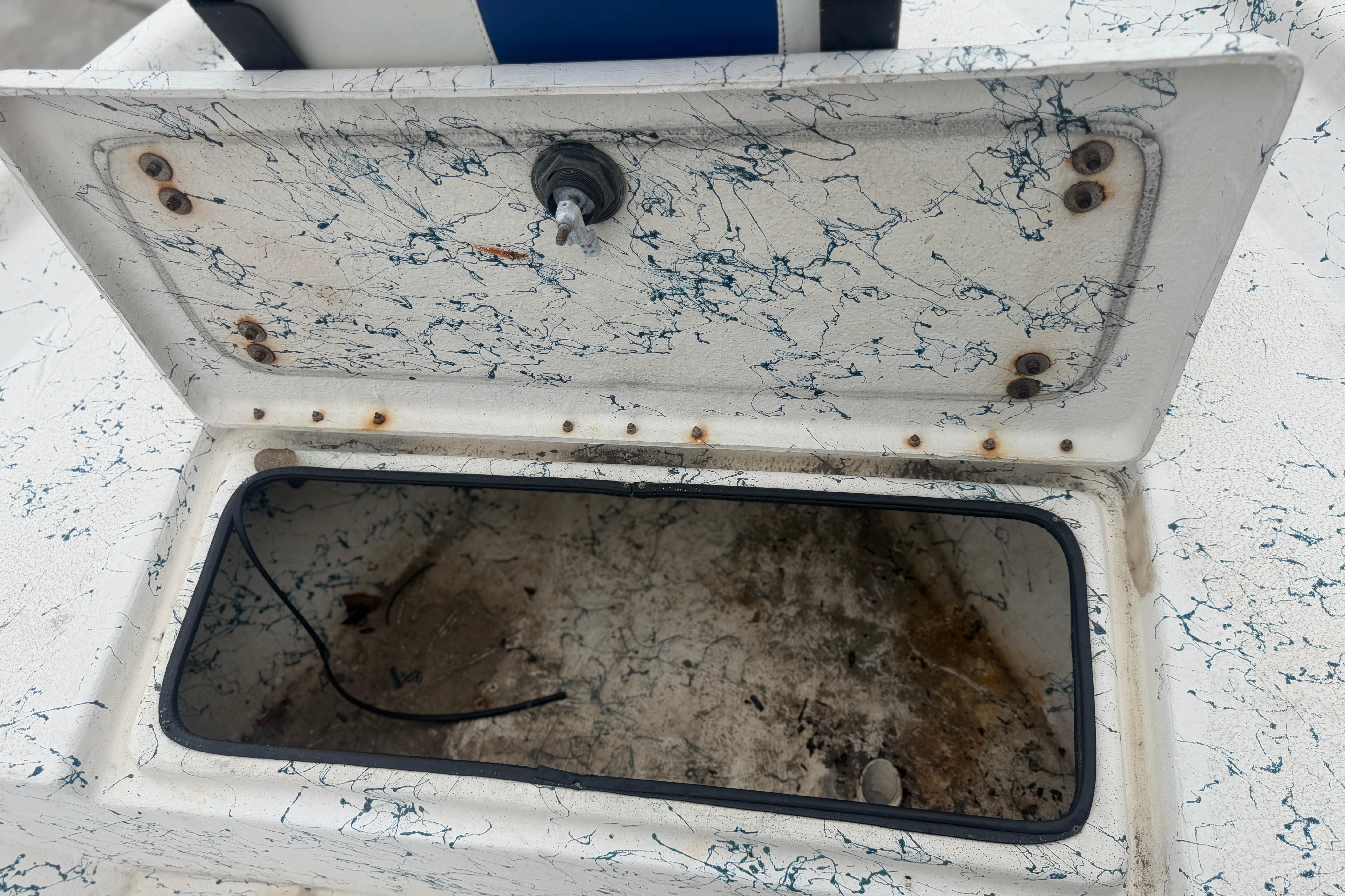 Open storage compartment on a 2004 Blue Wave 160 V-Bay boat, showing interior details.